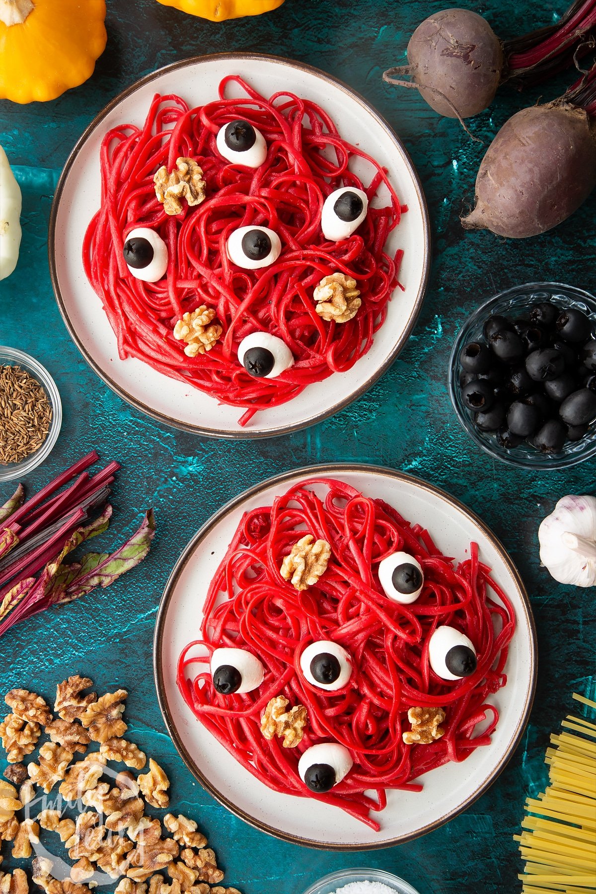 Two plates with a beetroot Halloween pasta recipe, topped with mozzarella eyes and walnut brains.