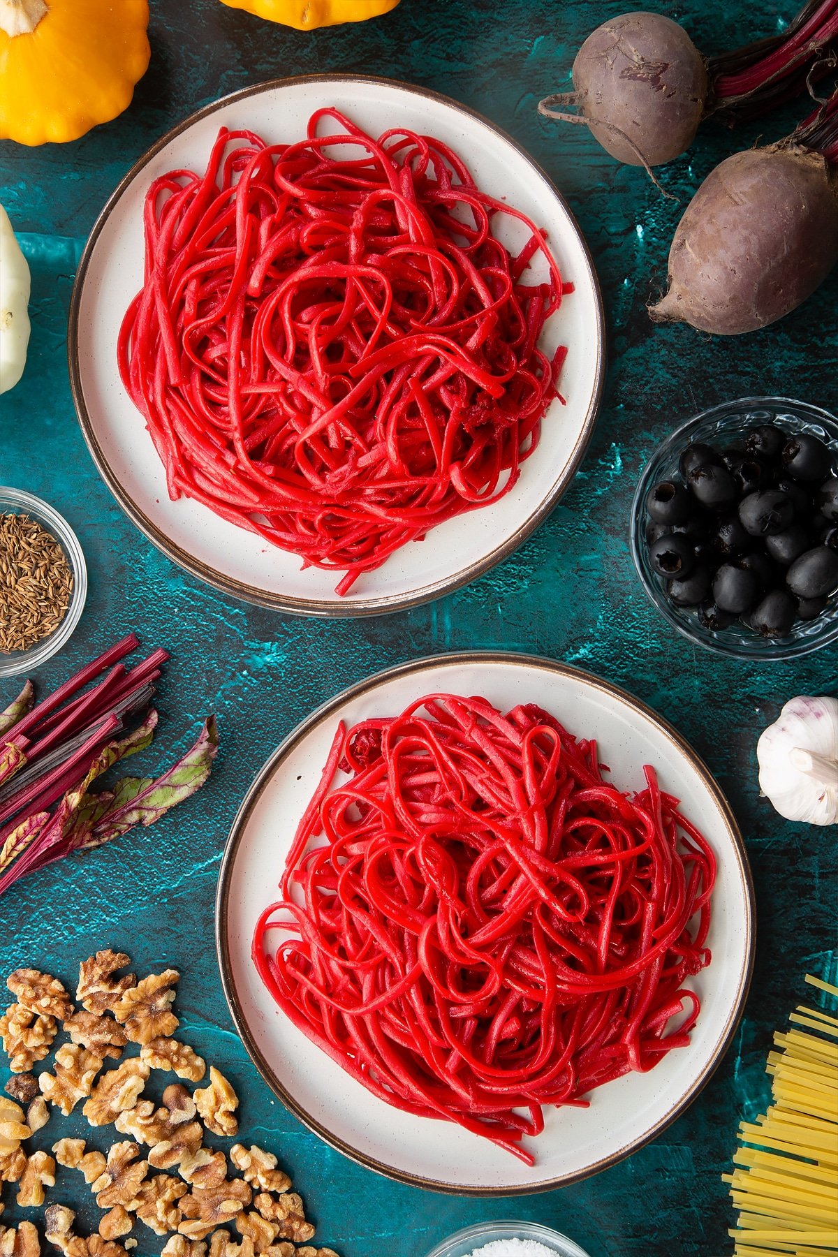 Two plates with beetroot pasta.