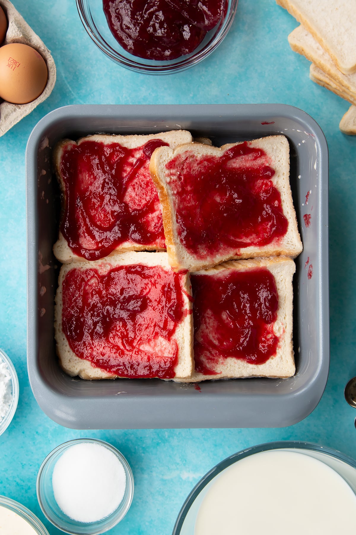 Spreading the remaining jam on the bread inside the baking tin.