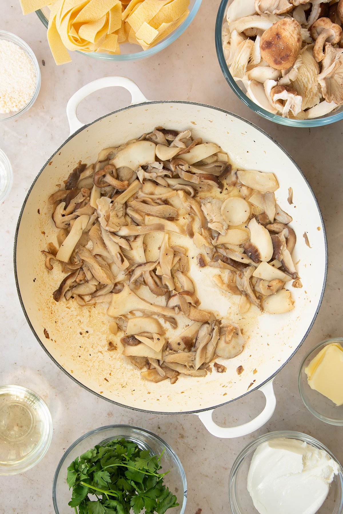 cooked garlic and mushrooms in a wine sauce in a large pan.