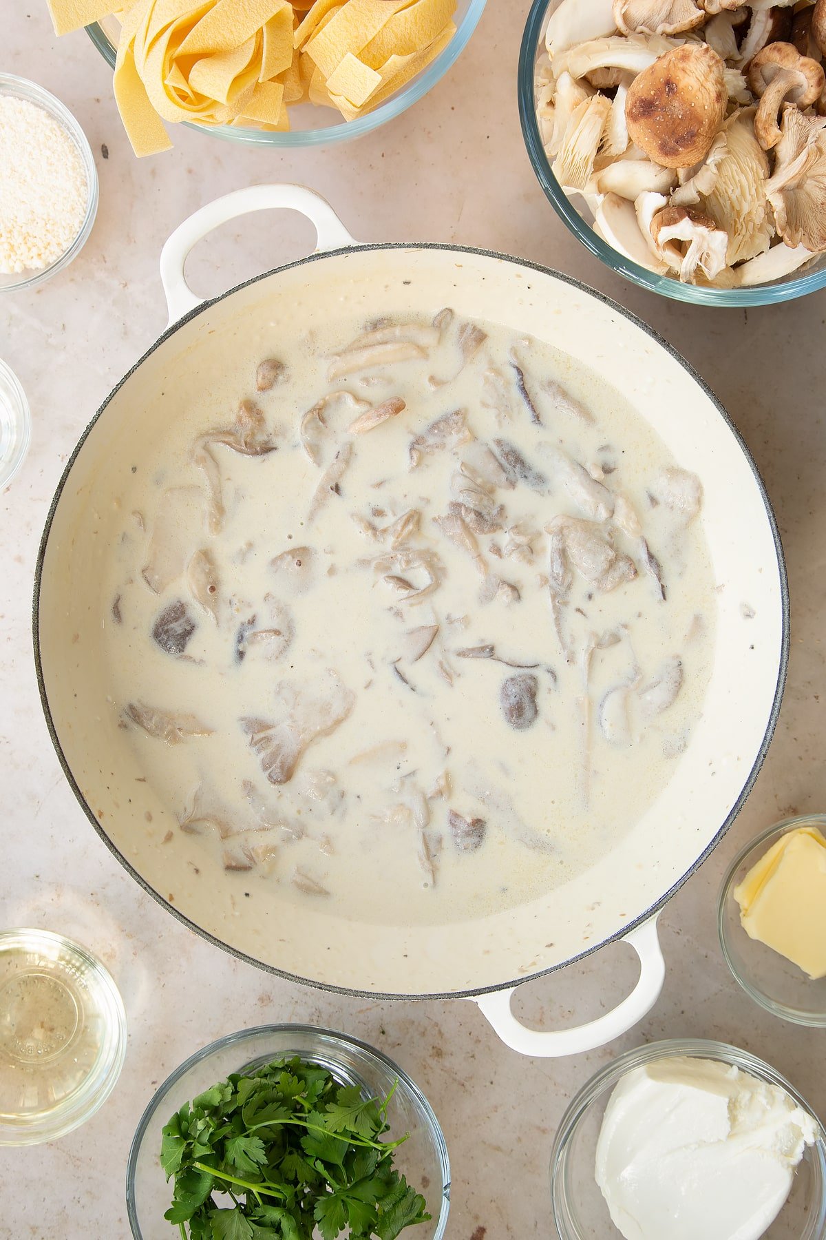 stirred milk and cream cheese sauce with mushrooms in a large pan.