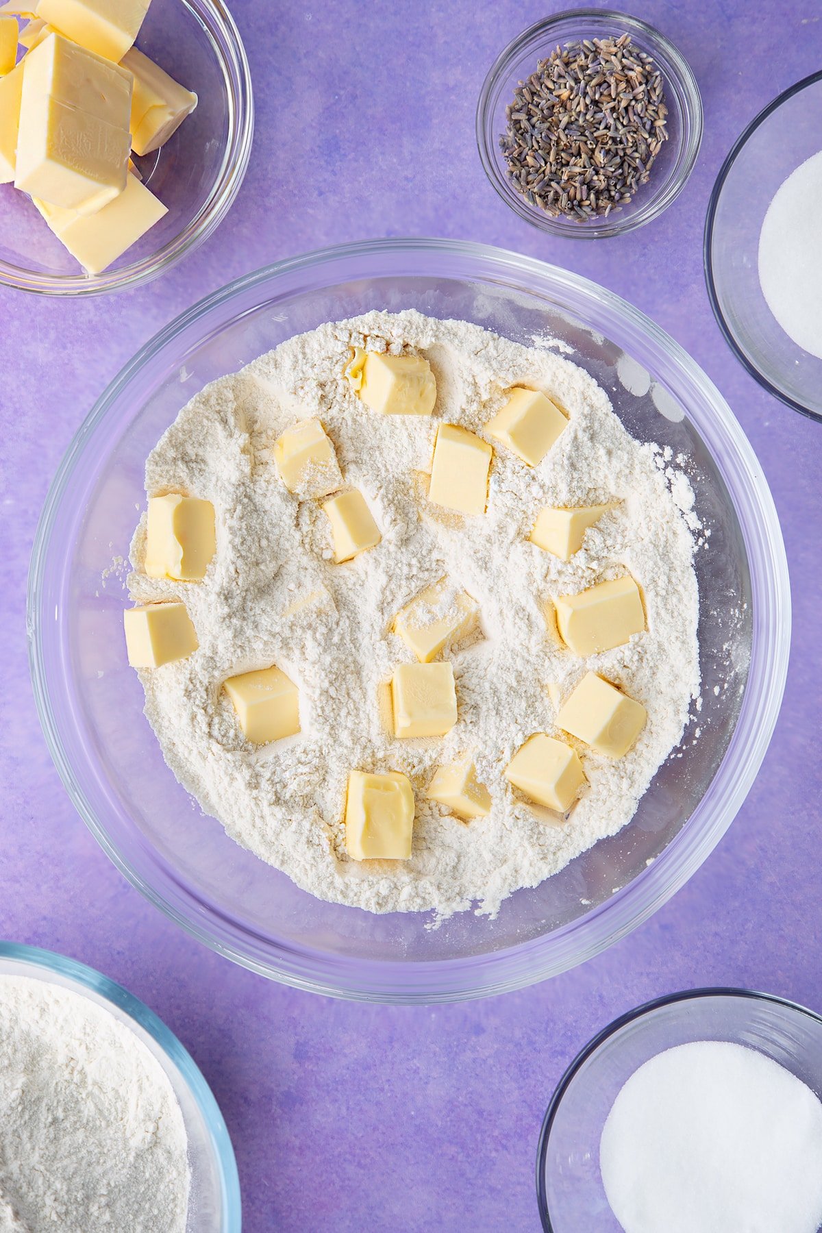 Flour, sugar with cubed butter on top in a bowl. Ingredients to make lavender shortbread cookies.