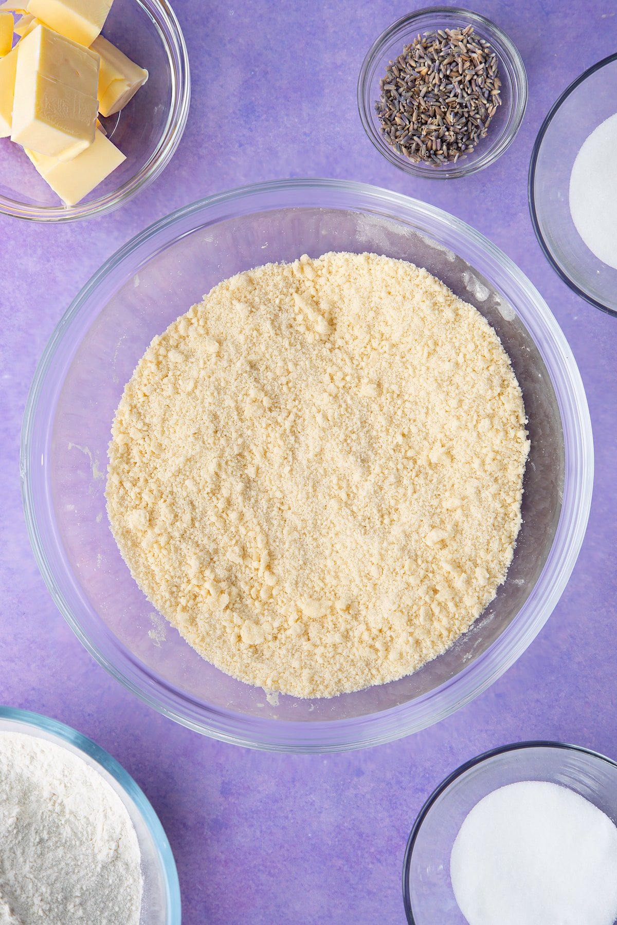 Flour, sugar, butter mixed to a crumb in a bowl. Ingredients to make lavender shortbread cookies.