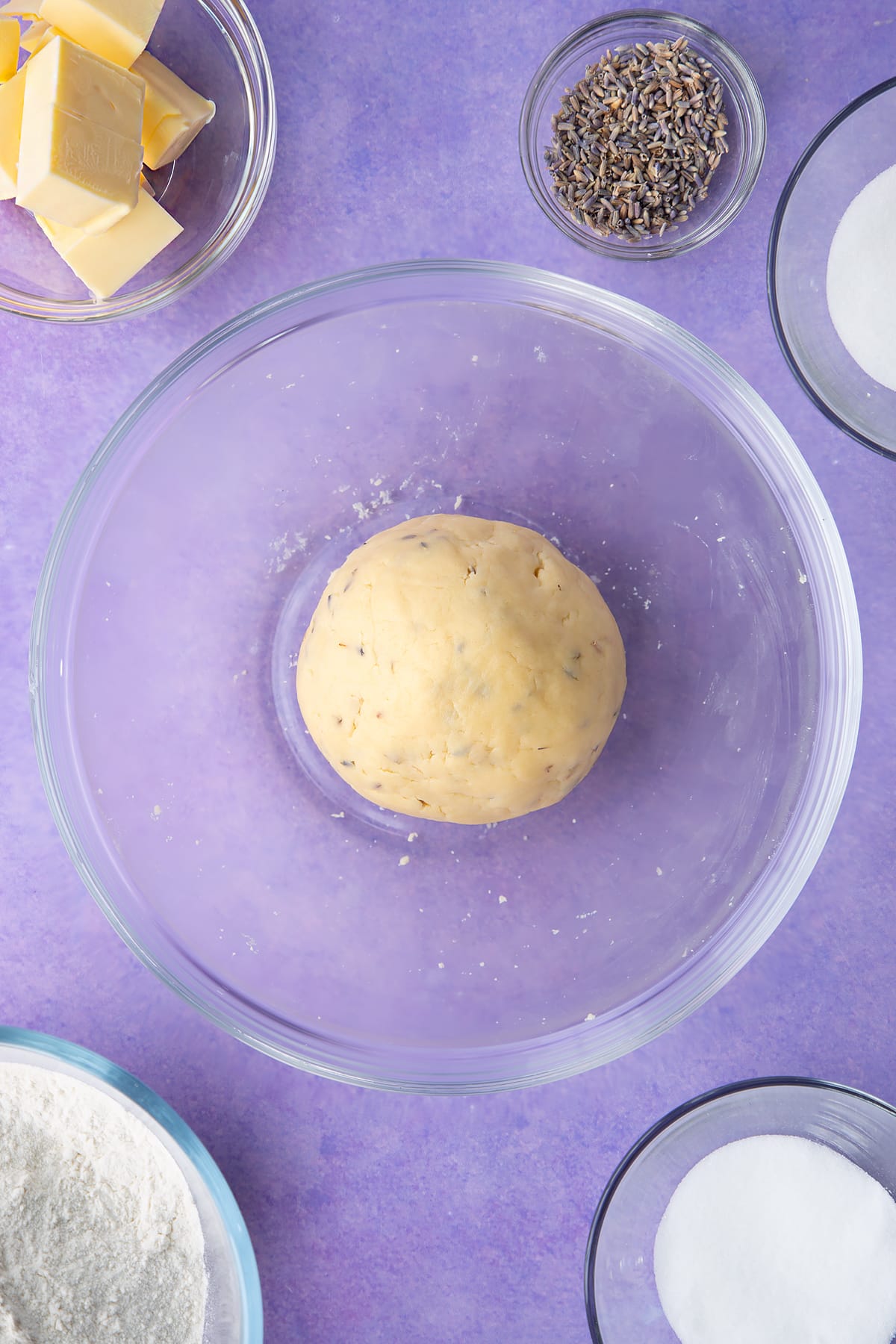 Lavender shortbread cookie dough in a ball in a mixing bowl.