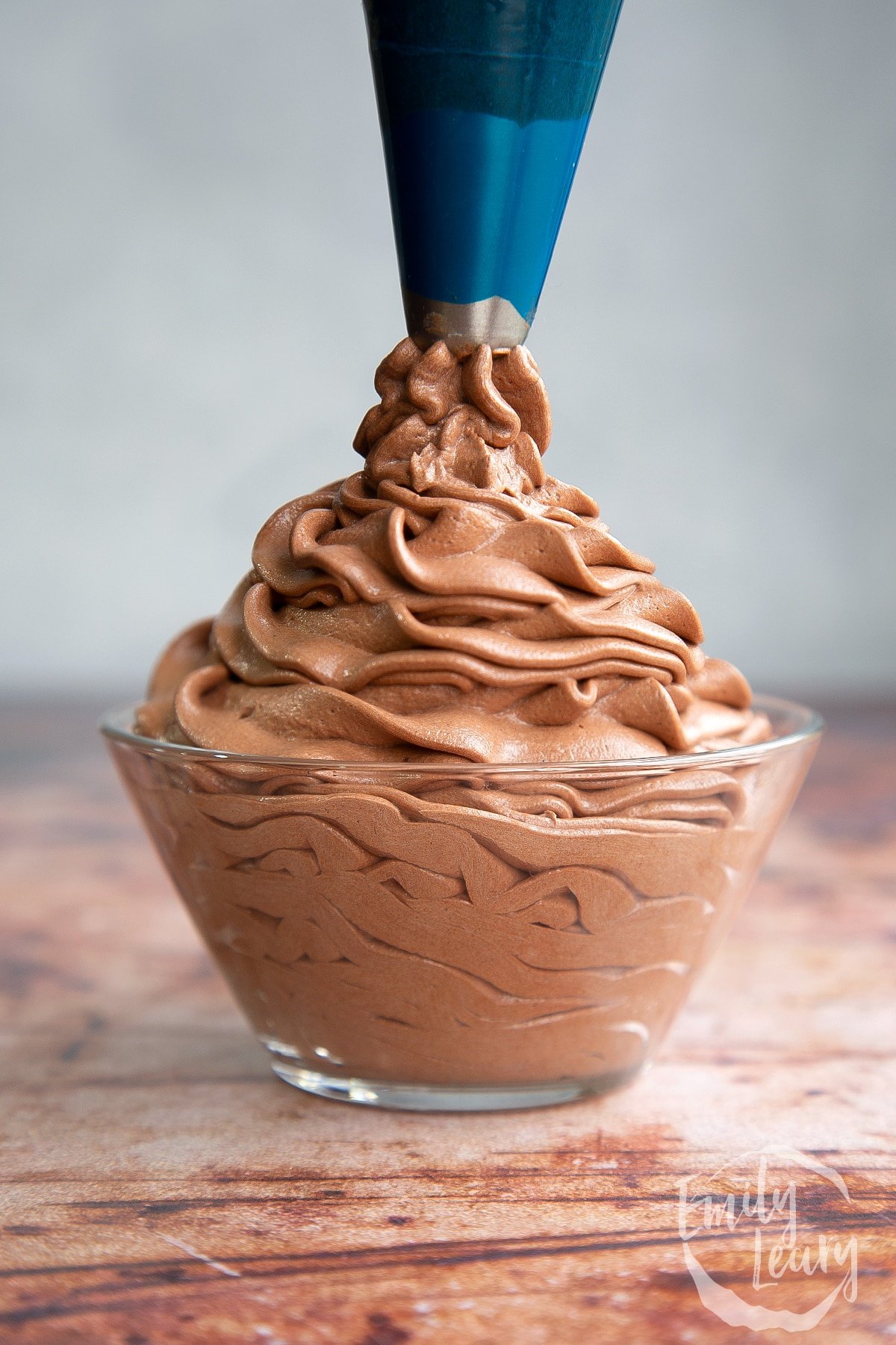 Nutella buttercream being piped into a bowl.