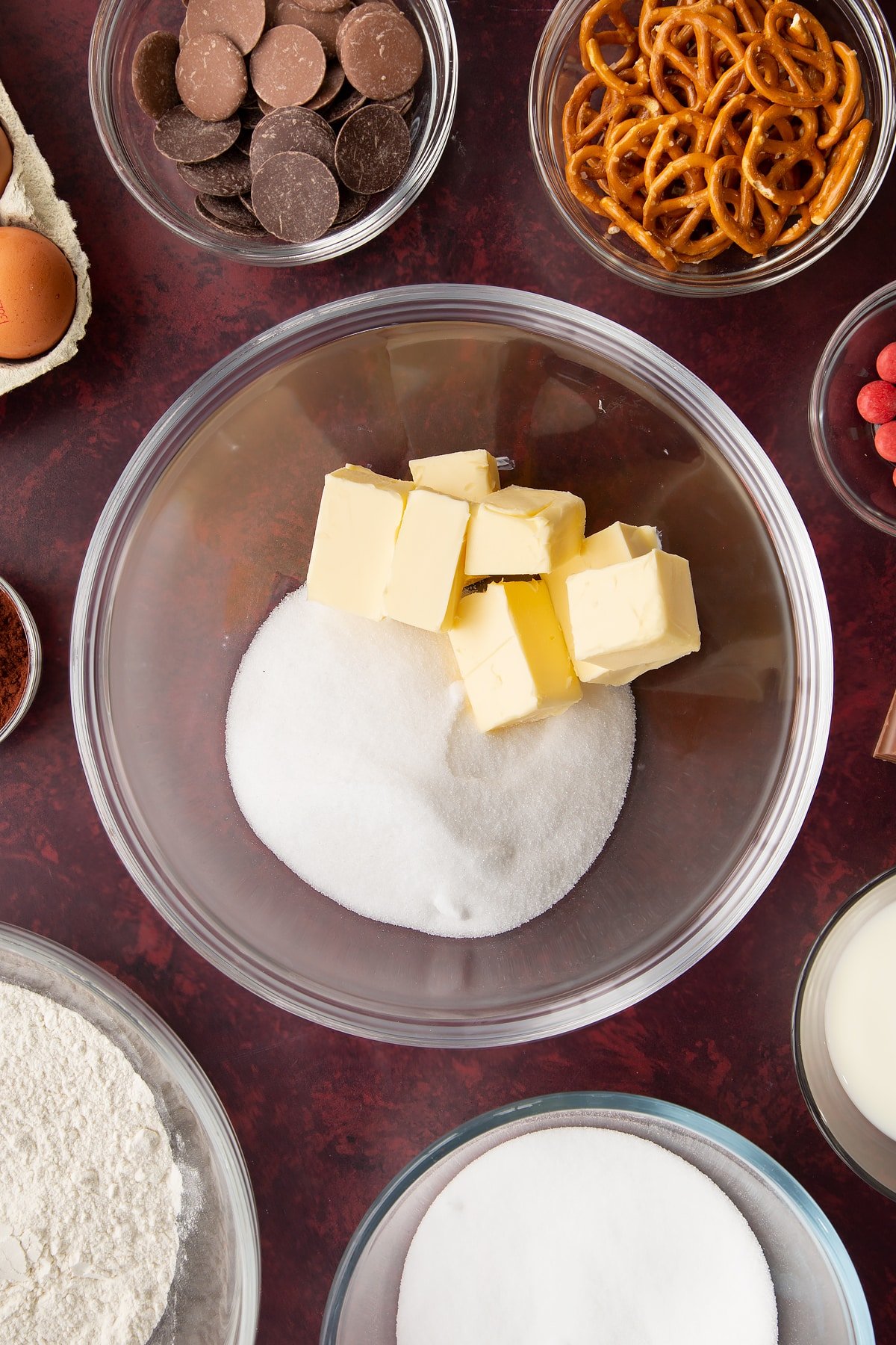 Softened butter and caster sugar in a mixing bowl. Ingredients to make reindeer cupcakes surround the bowl.