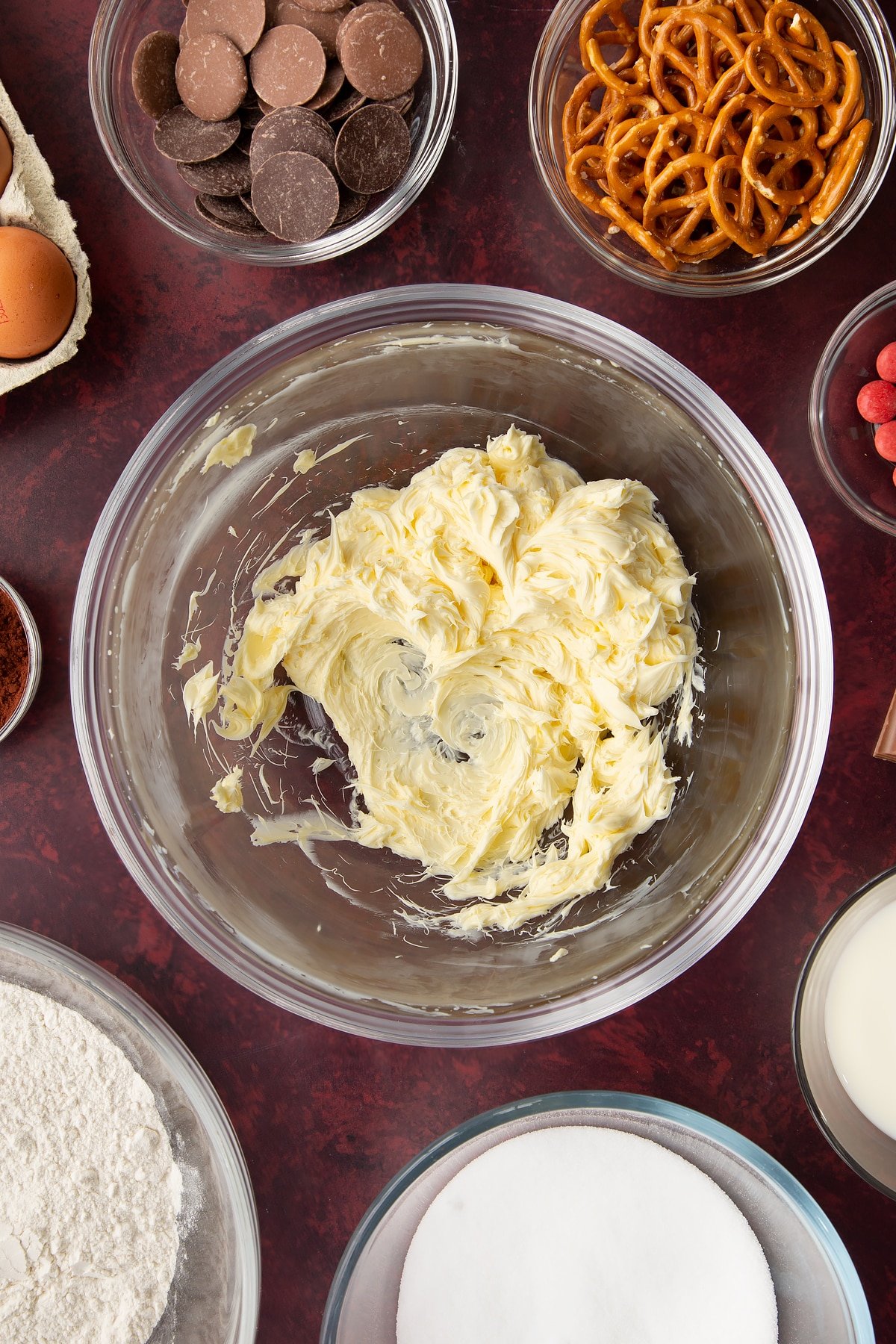 Whipped softened butter in a mixing bowl. Ingredients to make reindeer cupcakes surround the bowl.