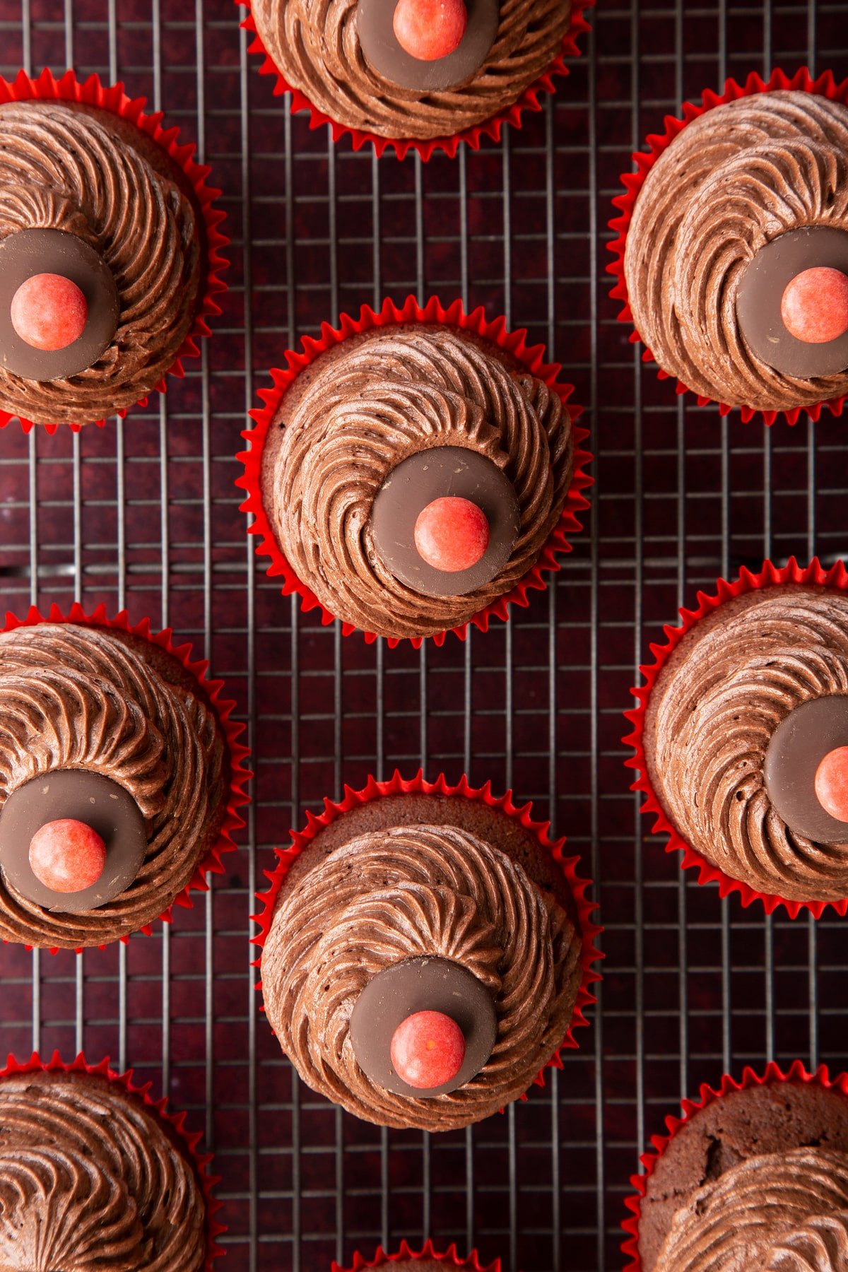 Reindeer cupcakes shown from above on a wire rack. They don't have eyes or antlers yet.