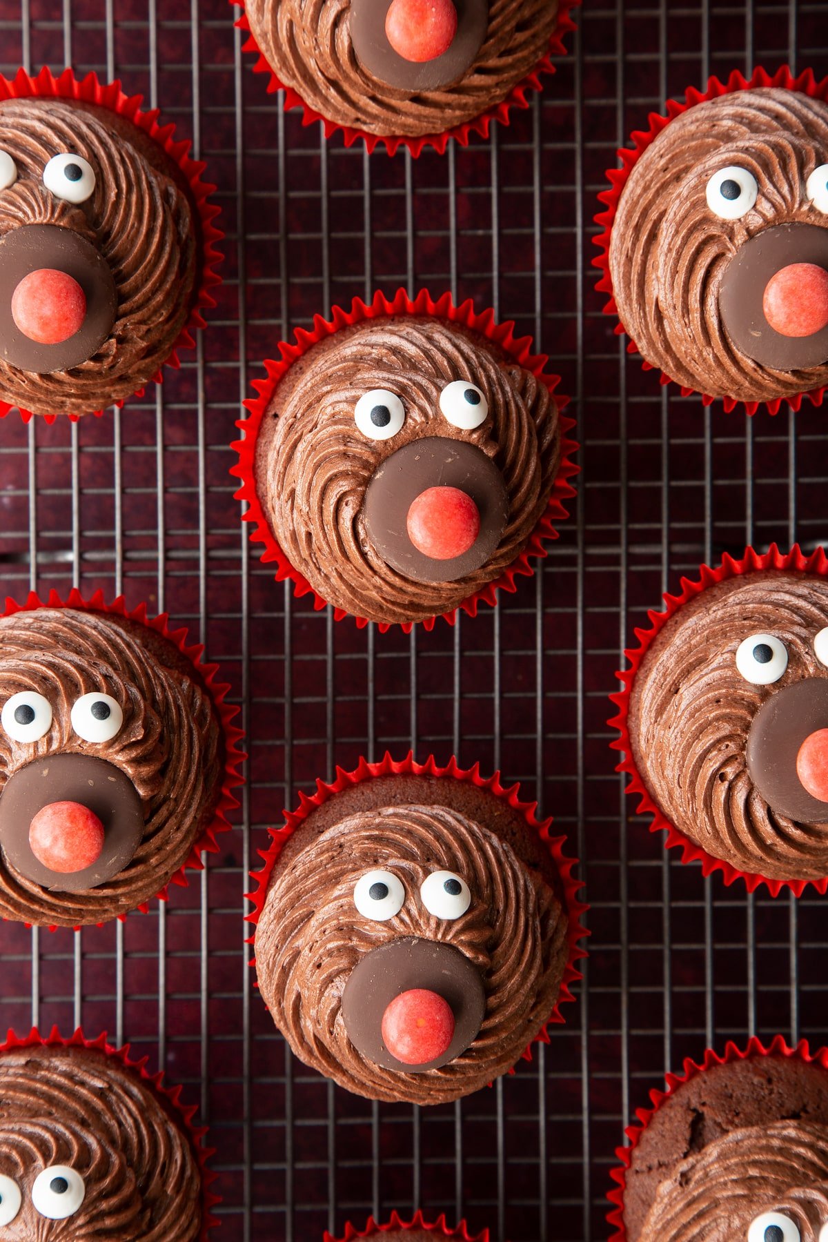 Reindeer cupcakes shown from above on a wire rack. They don't have antlers yet.