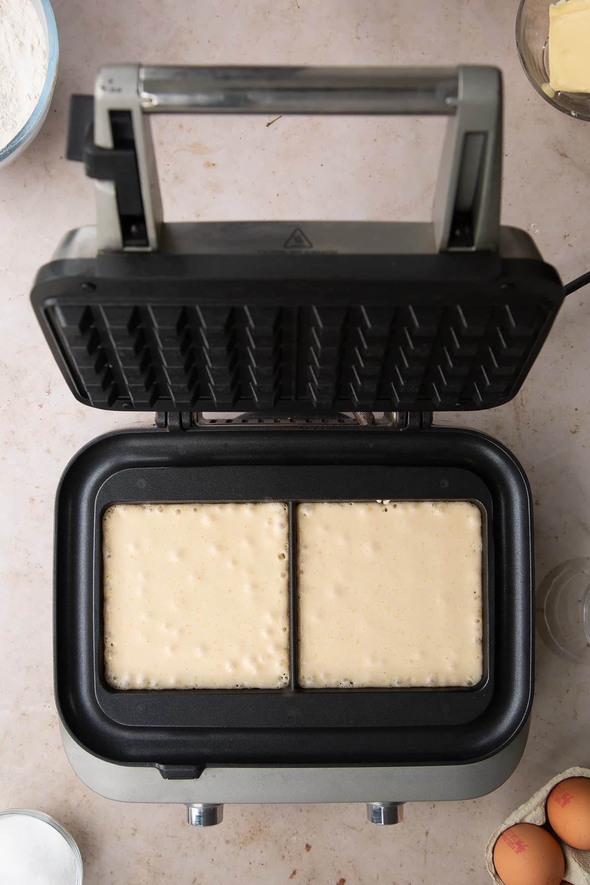 2 waffle moulds filled with batter in the sage smart waffle maker.