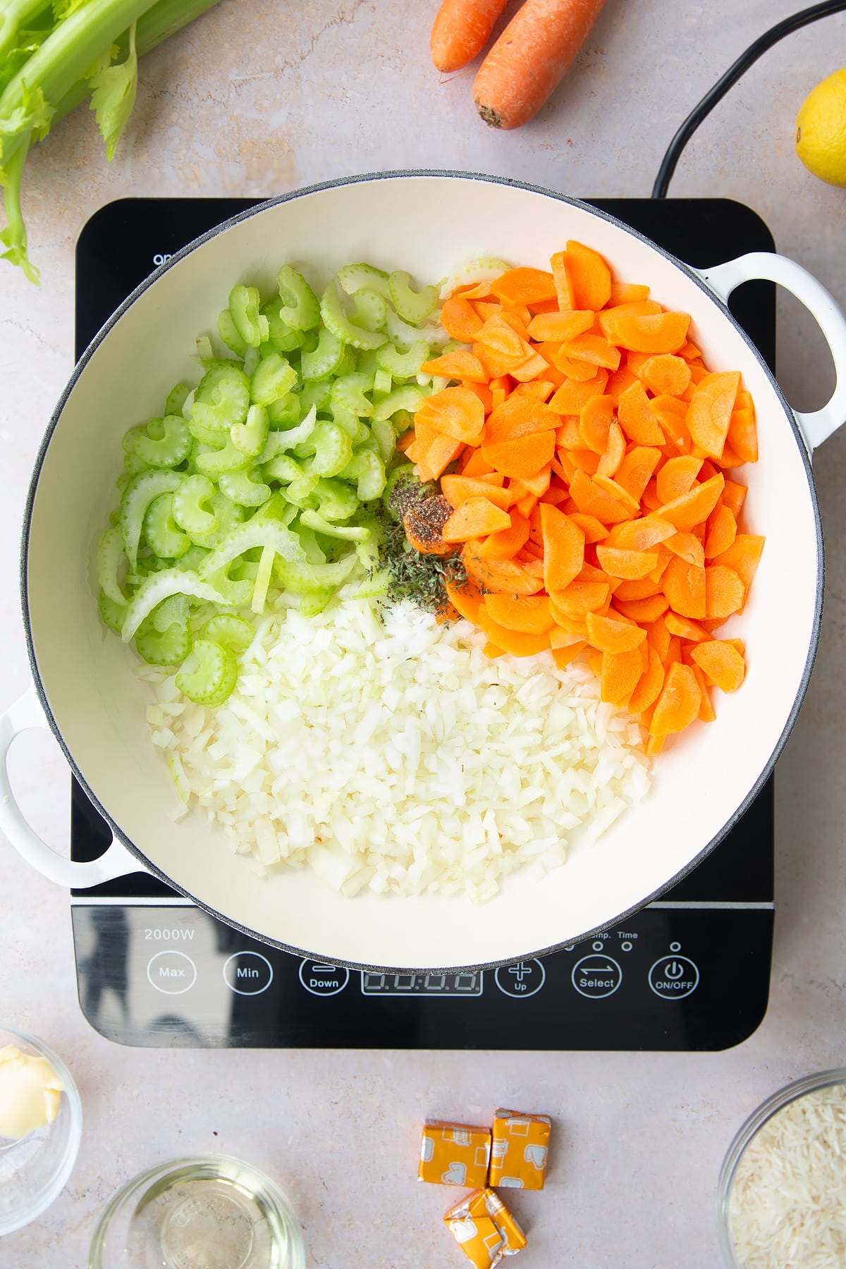 Overhead shot of the diced vegetables for the turkey rice soup in a pan.