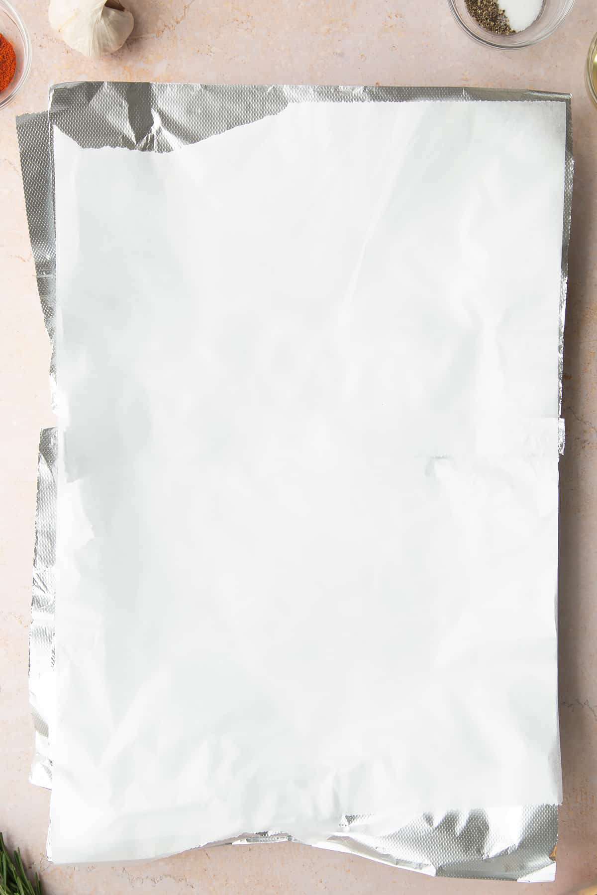 Layers of paper and foil packet on a baking tray.