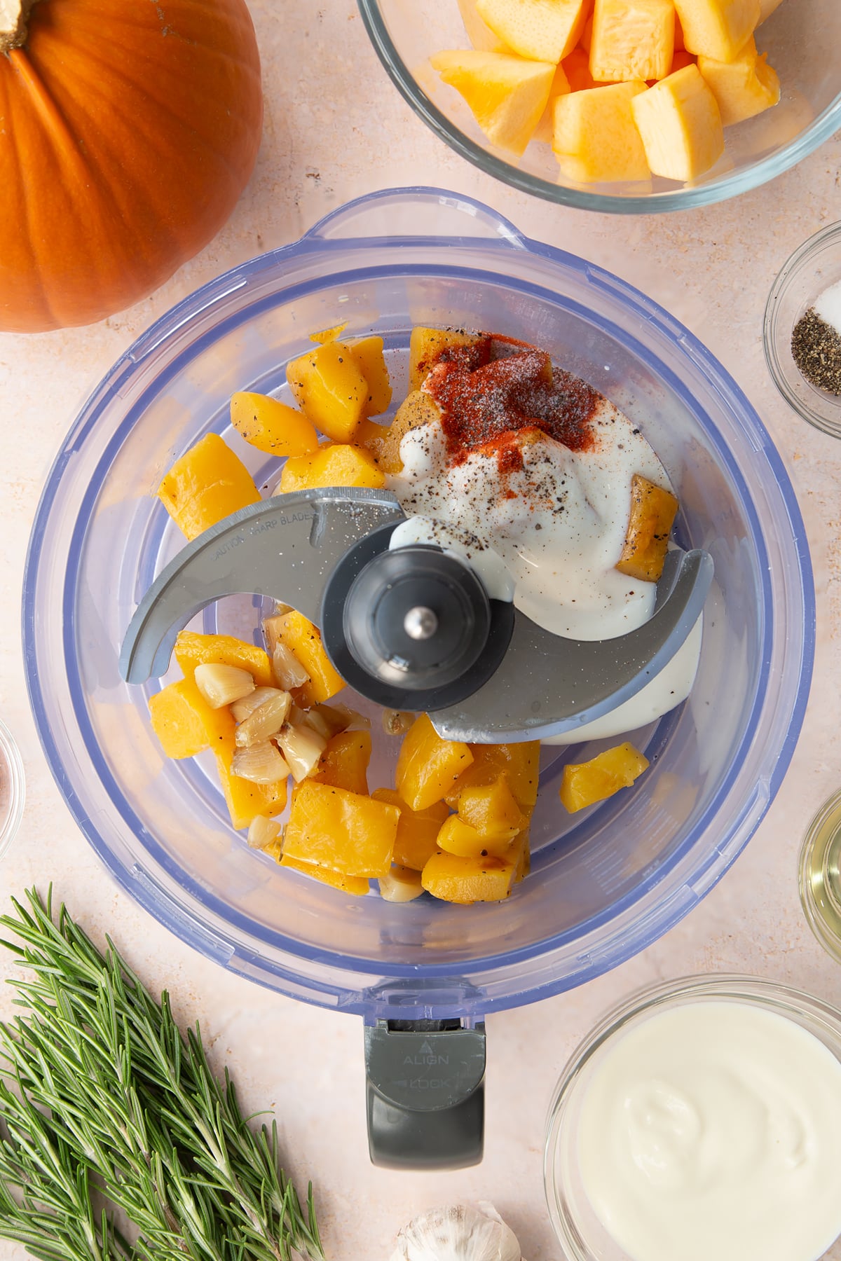 Roasted pumpkin and garlic, paprika and vegan yogurt in a food processor bowl.