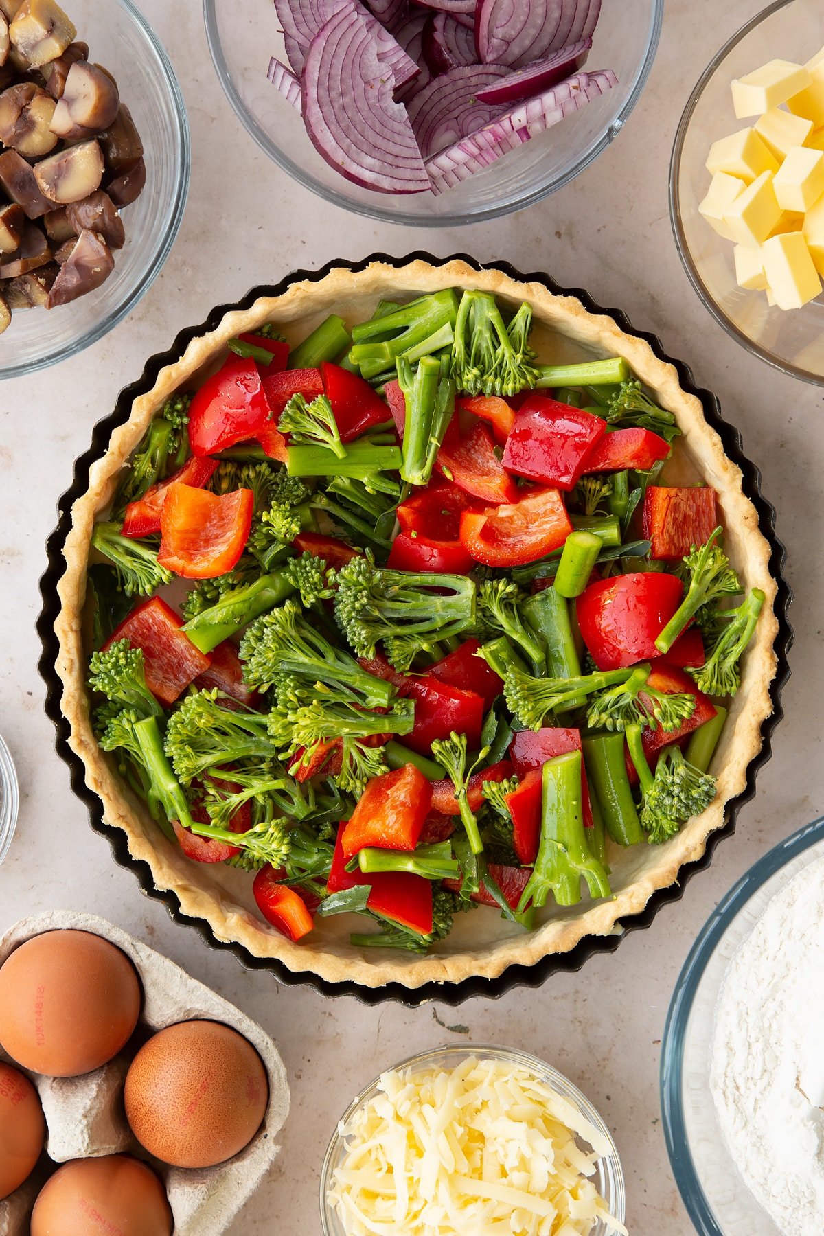 Overhead shot of the broccoli and sliced peppers inside the pastry case.