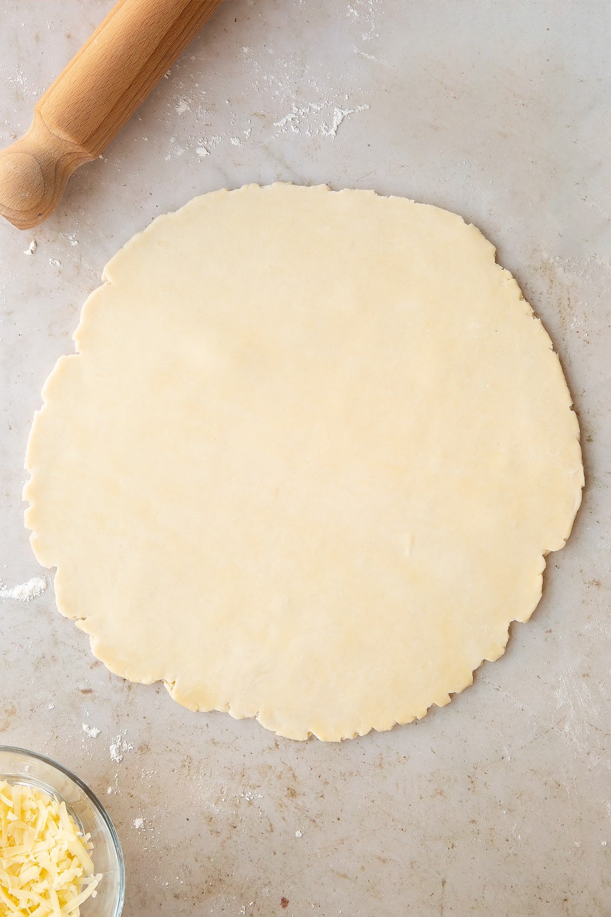 Overhead shot of the dough after it's been rolled out using a rolling pin.