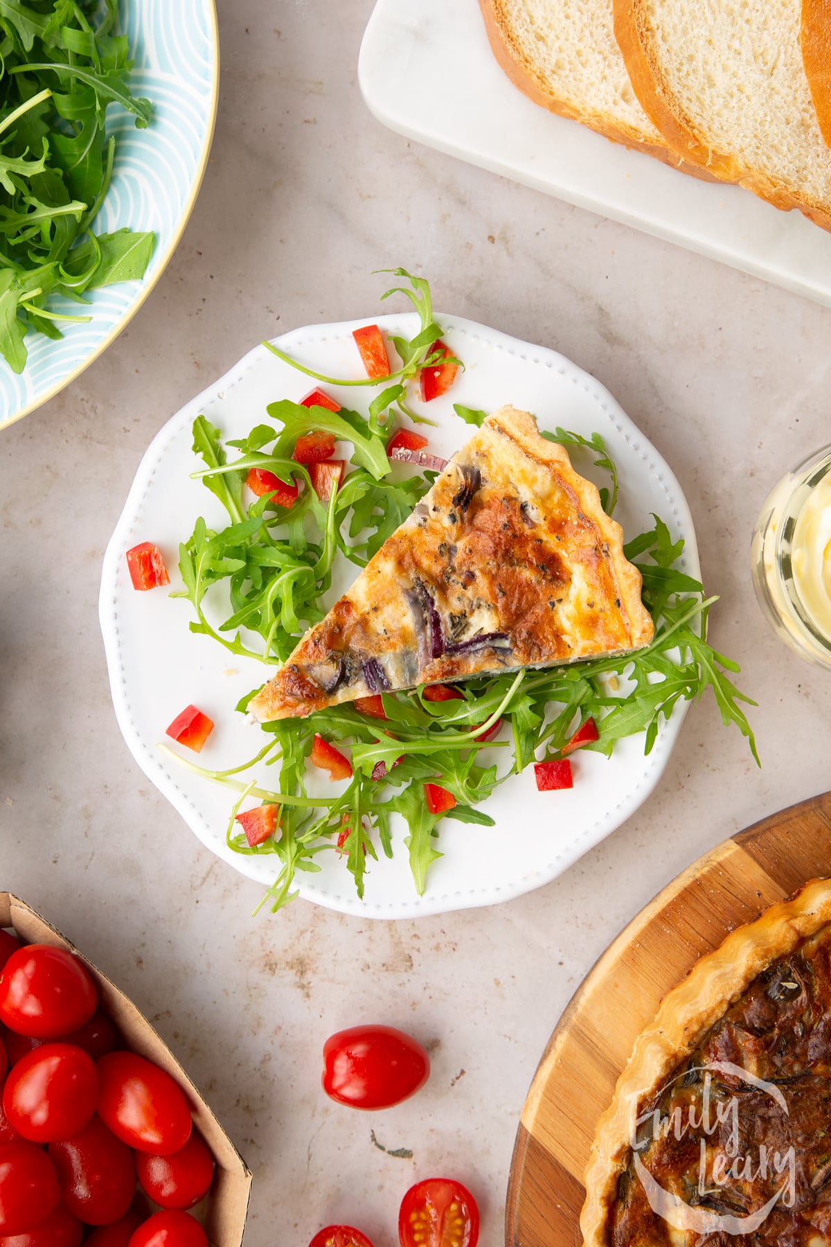 Overhead shot of the finished slice of chestnut quiche served on a decorative white plate with salad.