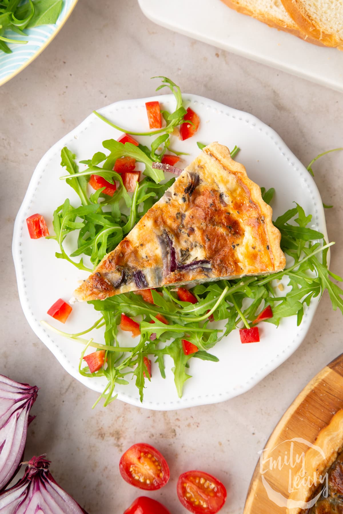 Close up overhead image of a slice of chestnut quiche served over a bed of salad. 