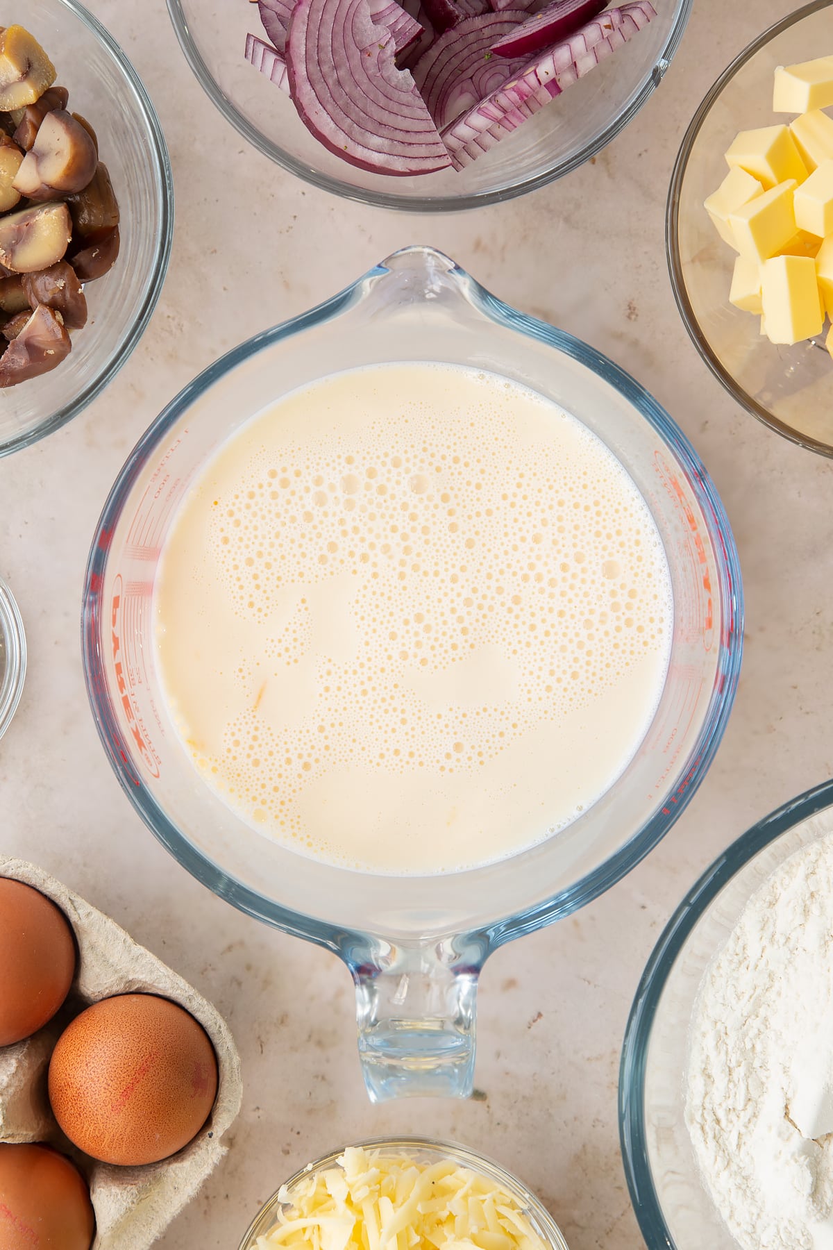 Overhead shot of milk and eggs in a jug having been mixed.