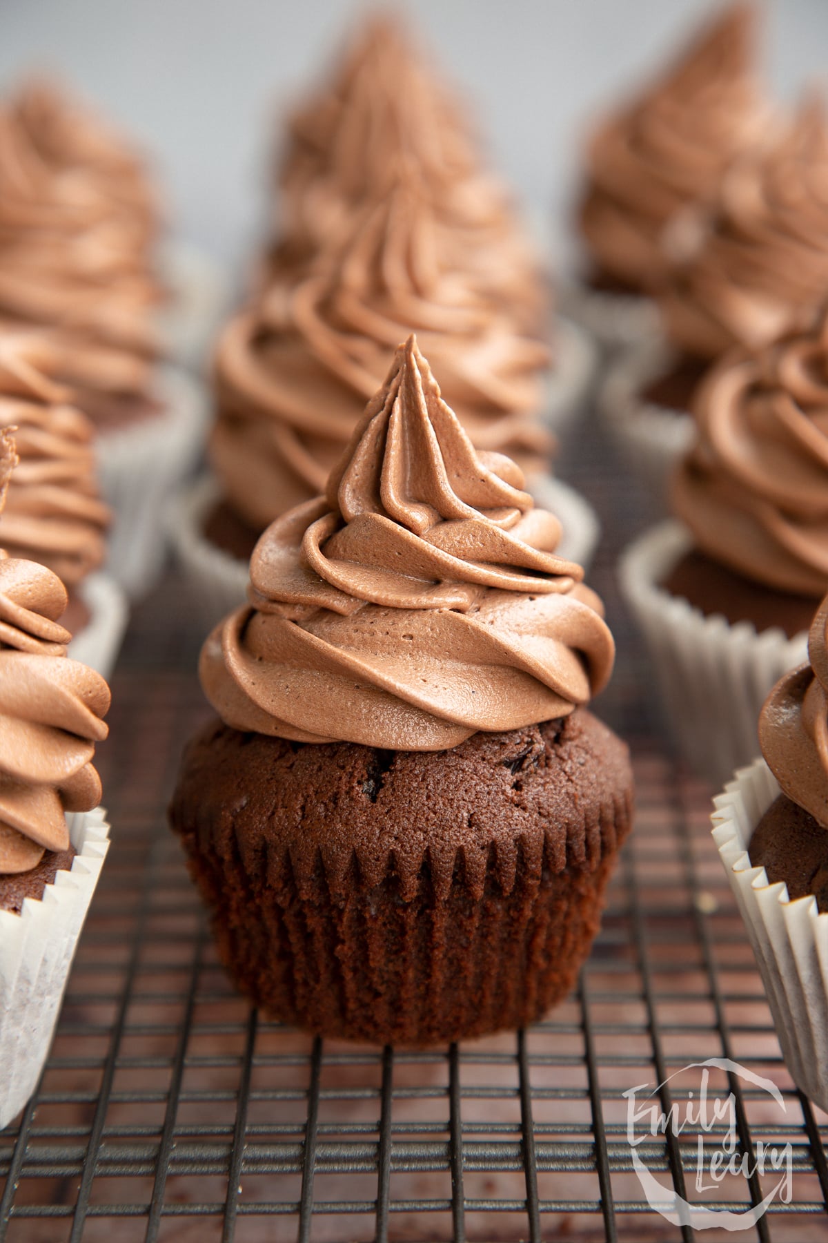 Nutella buttercream piped onto cupcakes. One is unwrapped.