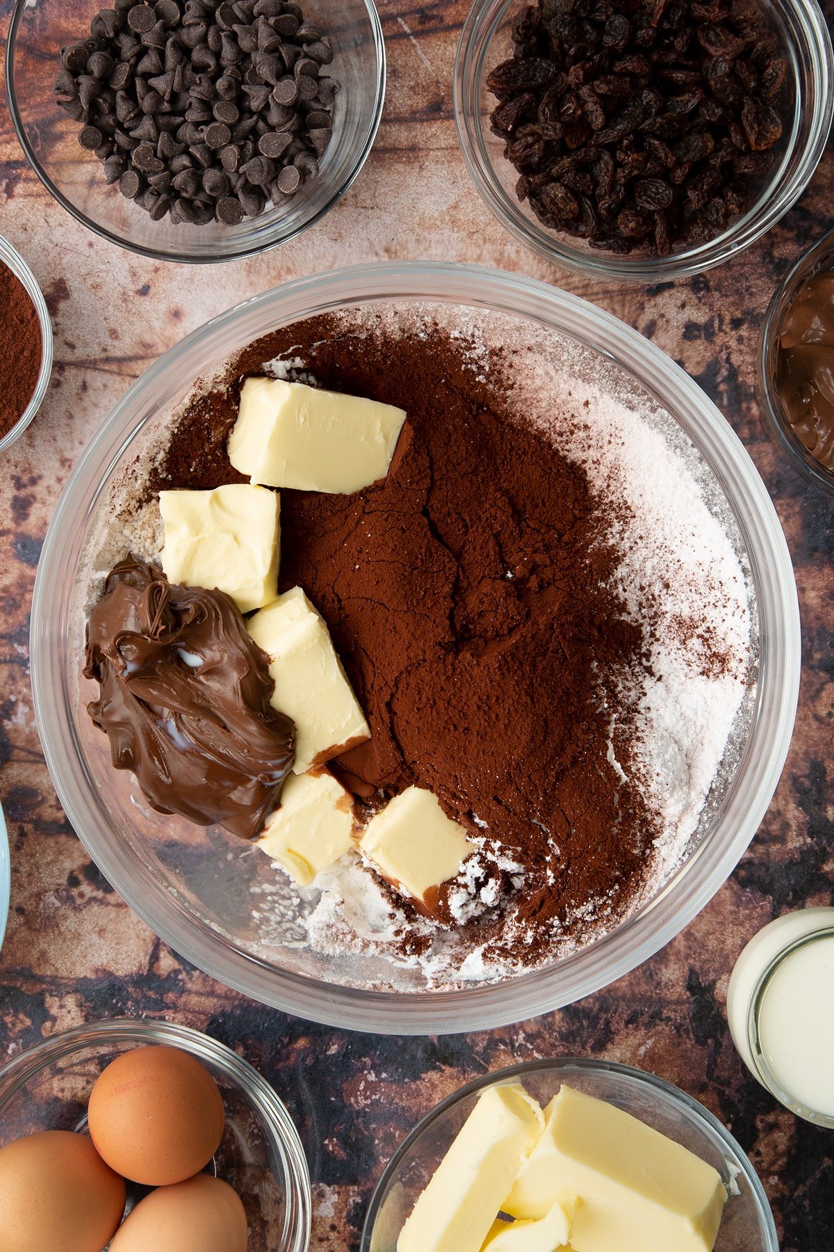 Butter, icing sugar, milk and Nutella in a bowl.