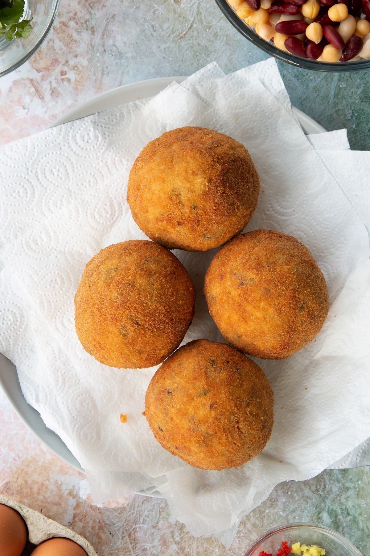 4 golden vegetarian scotch eggs on a paper towel base.