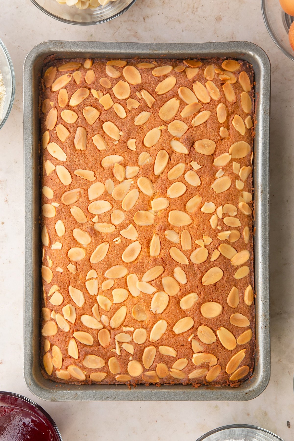 Bakewell tray bake in a tin, shown from above.