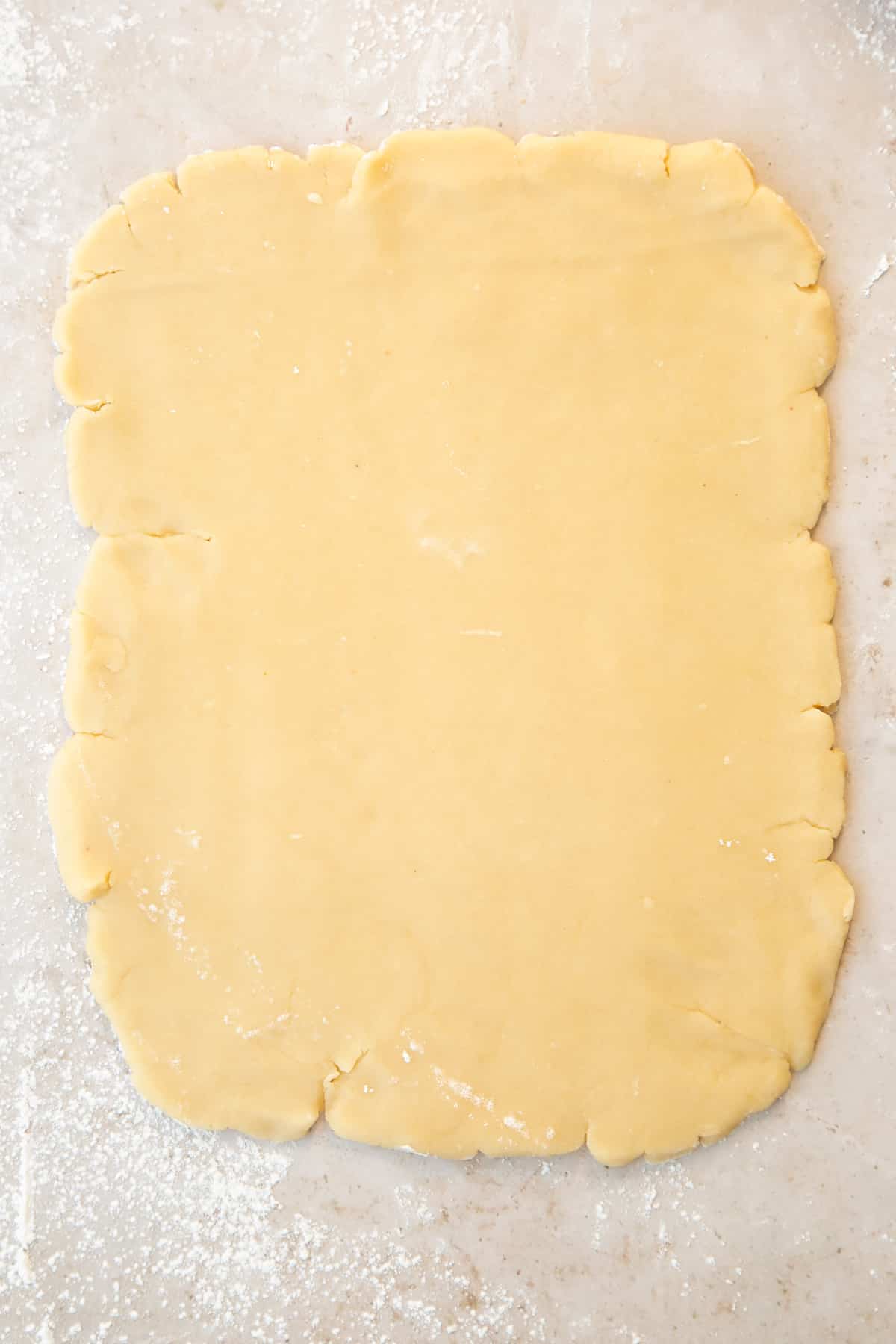 Pastry rolled out into a rectangle on a floured surface.