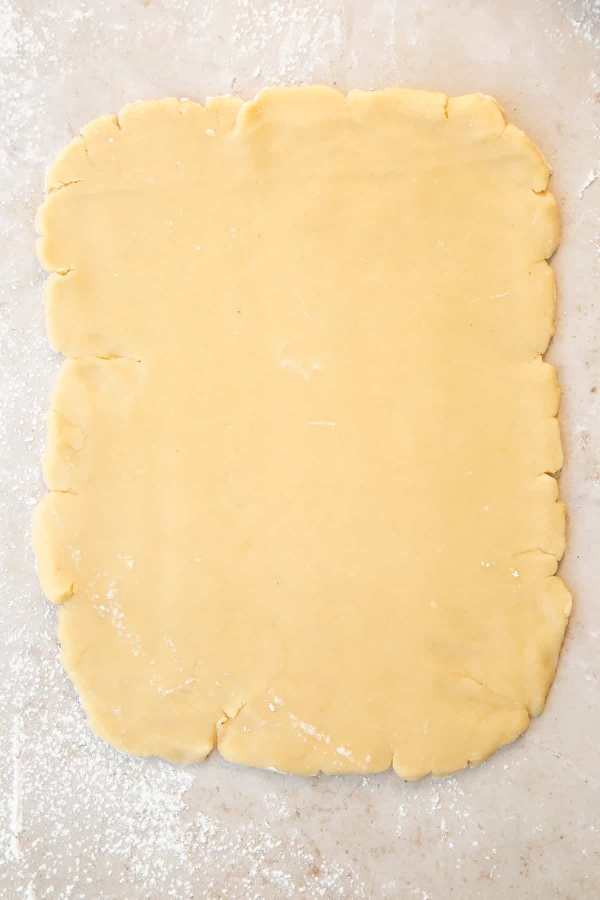 Pastry rolled out into a rectangle on a floured surface.
