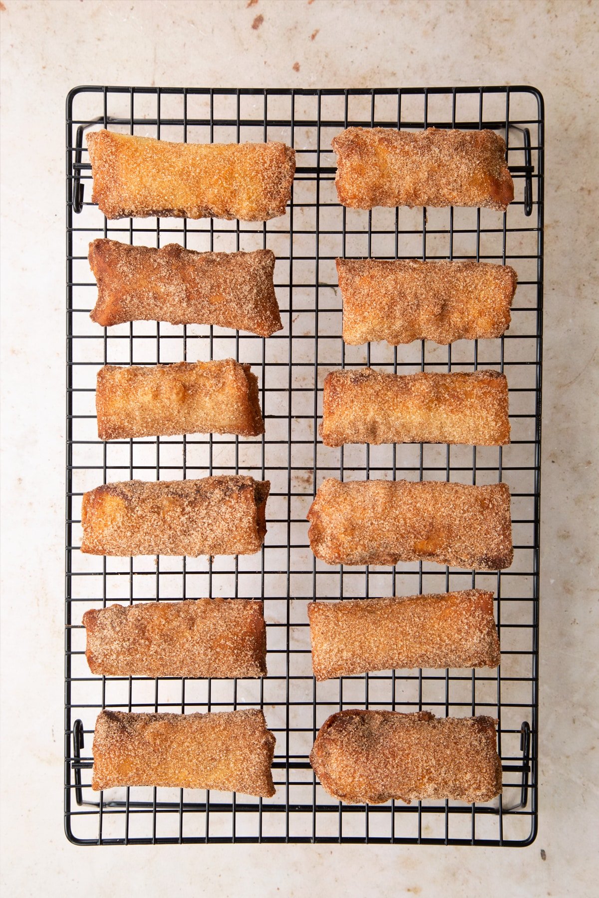 Finished banana chocolate spring rolls on a cooling rack.