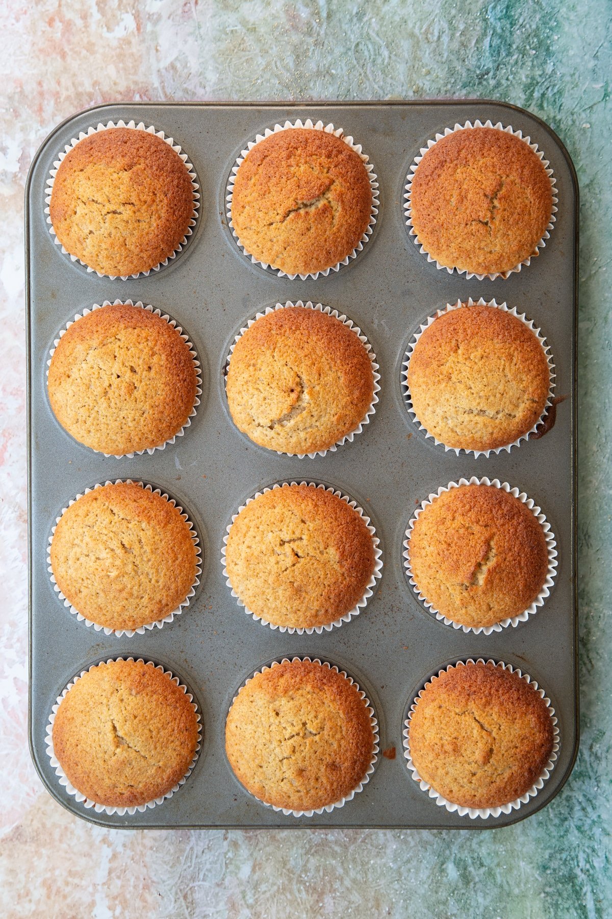 Banana cornmeal muffins in a muffin tray. 