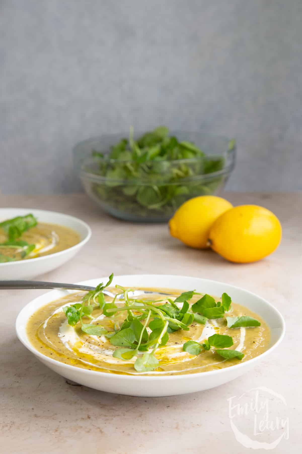 Side on shot of the broccoli and sweet potato soup served in a white bowl with a fork on the side.