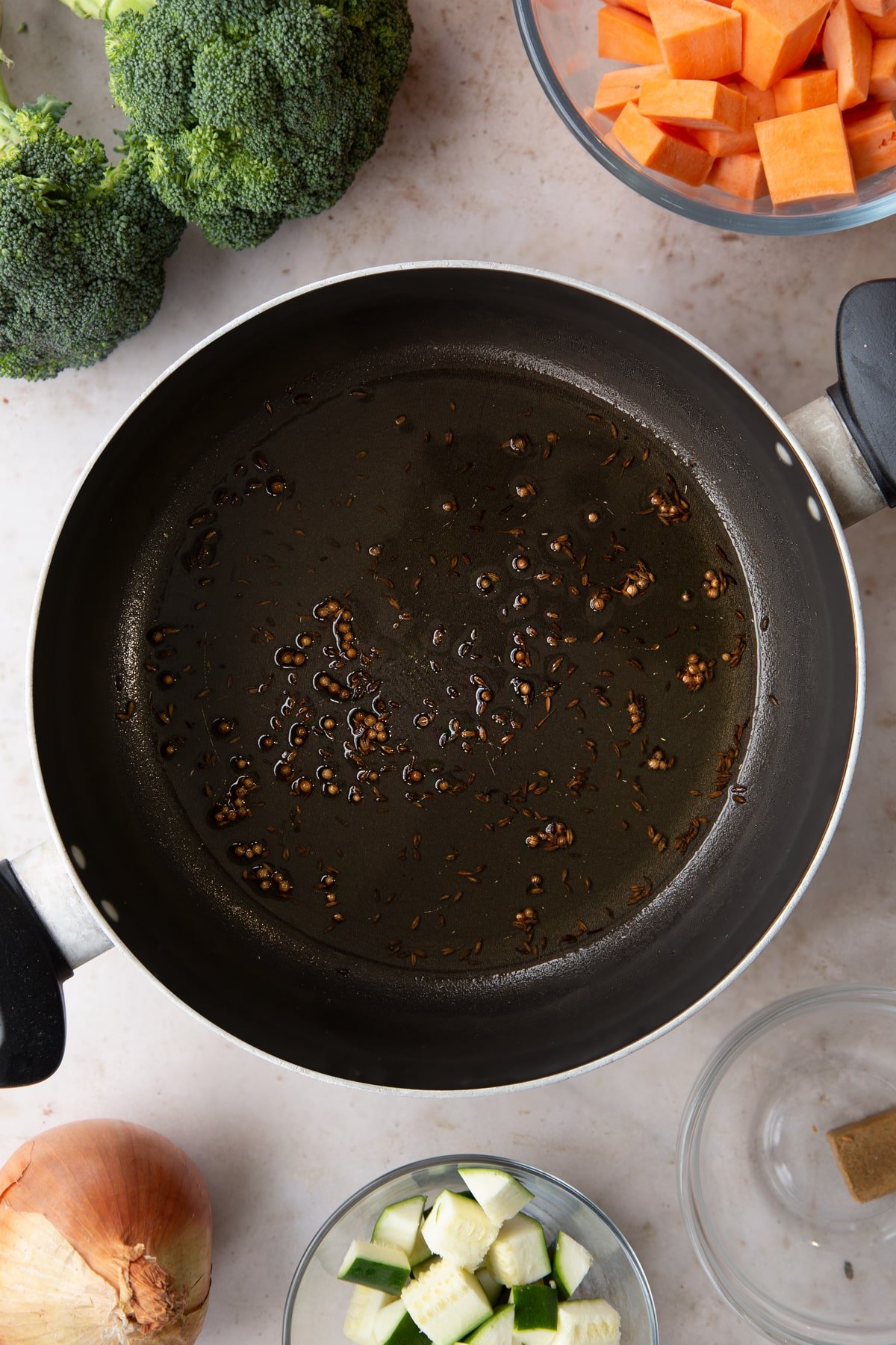 Overhead shot of some of the ingredients for the broccoli and sweet potato soup in a pan.