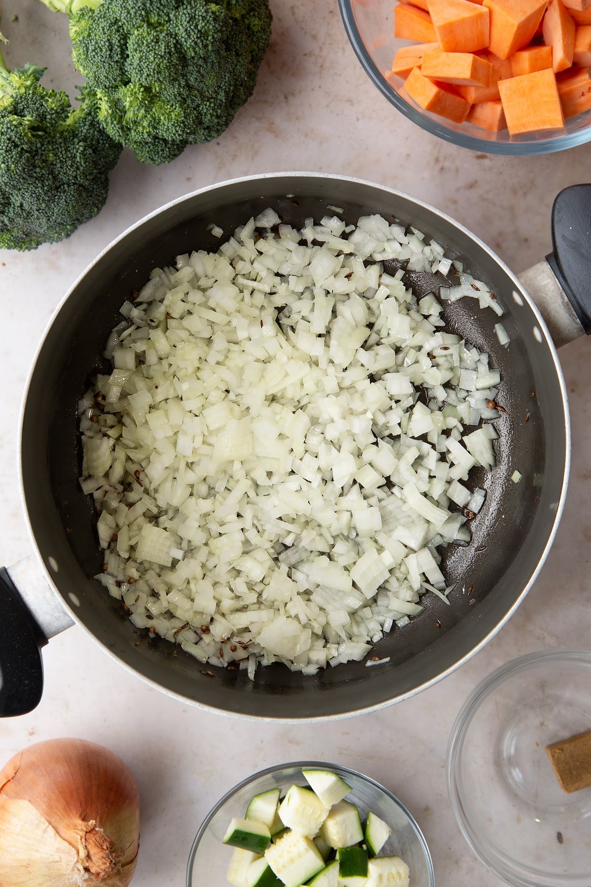 Overhead shot of the diced onions being added to the pan.