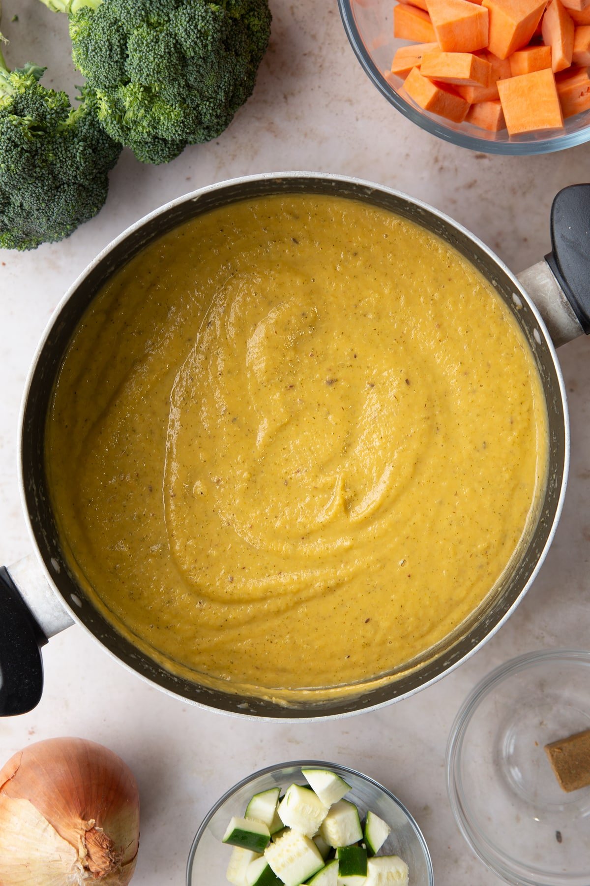 Overhead shot of the broccoli and sweet potato soup ingredients having been blended together in a pan.