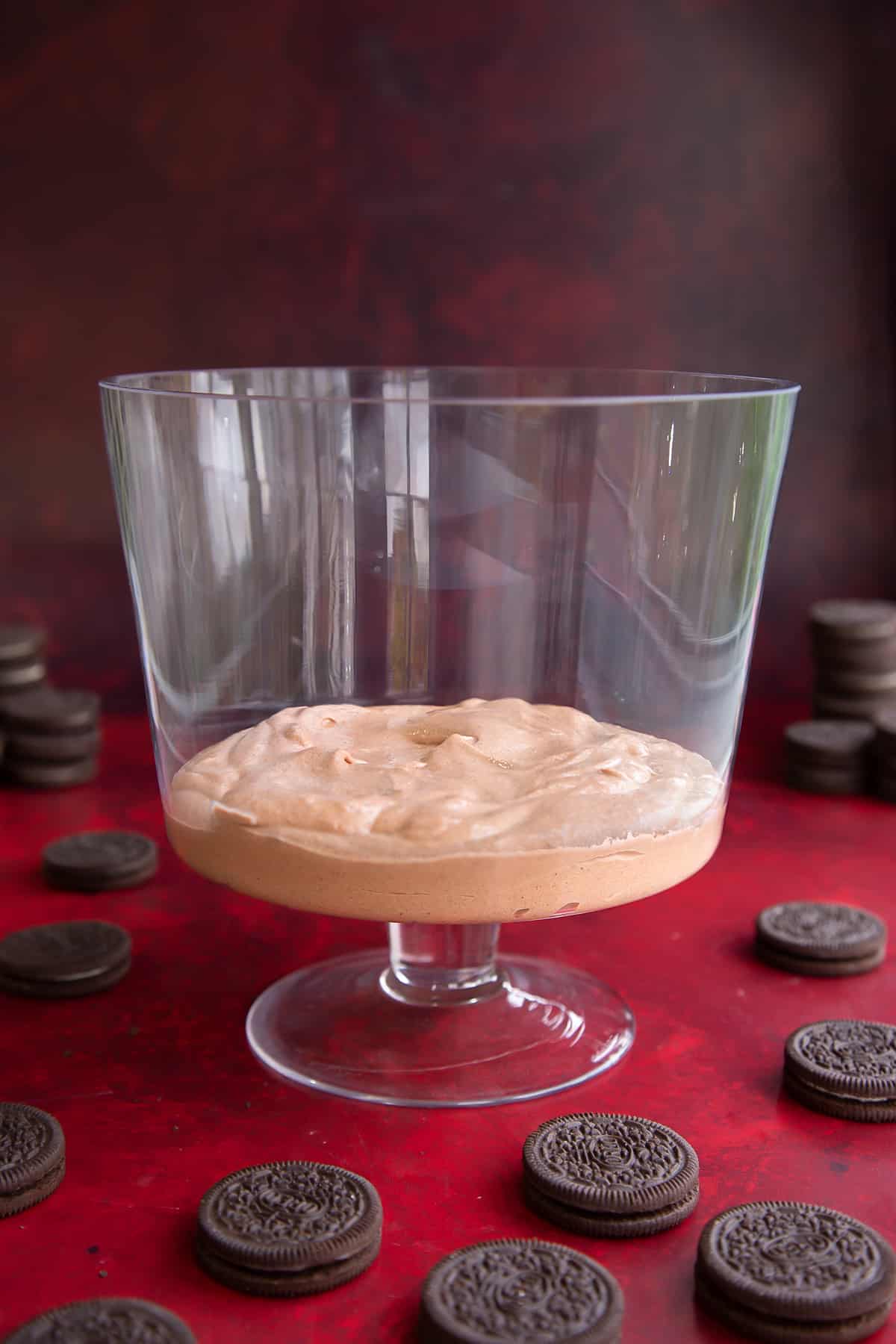 A layer of chocolate pudding in a trifle bowl.