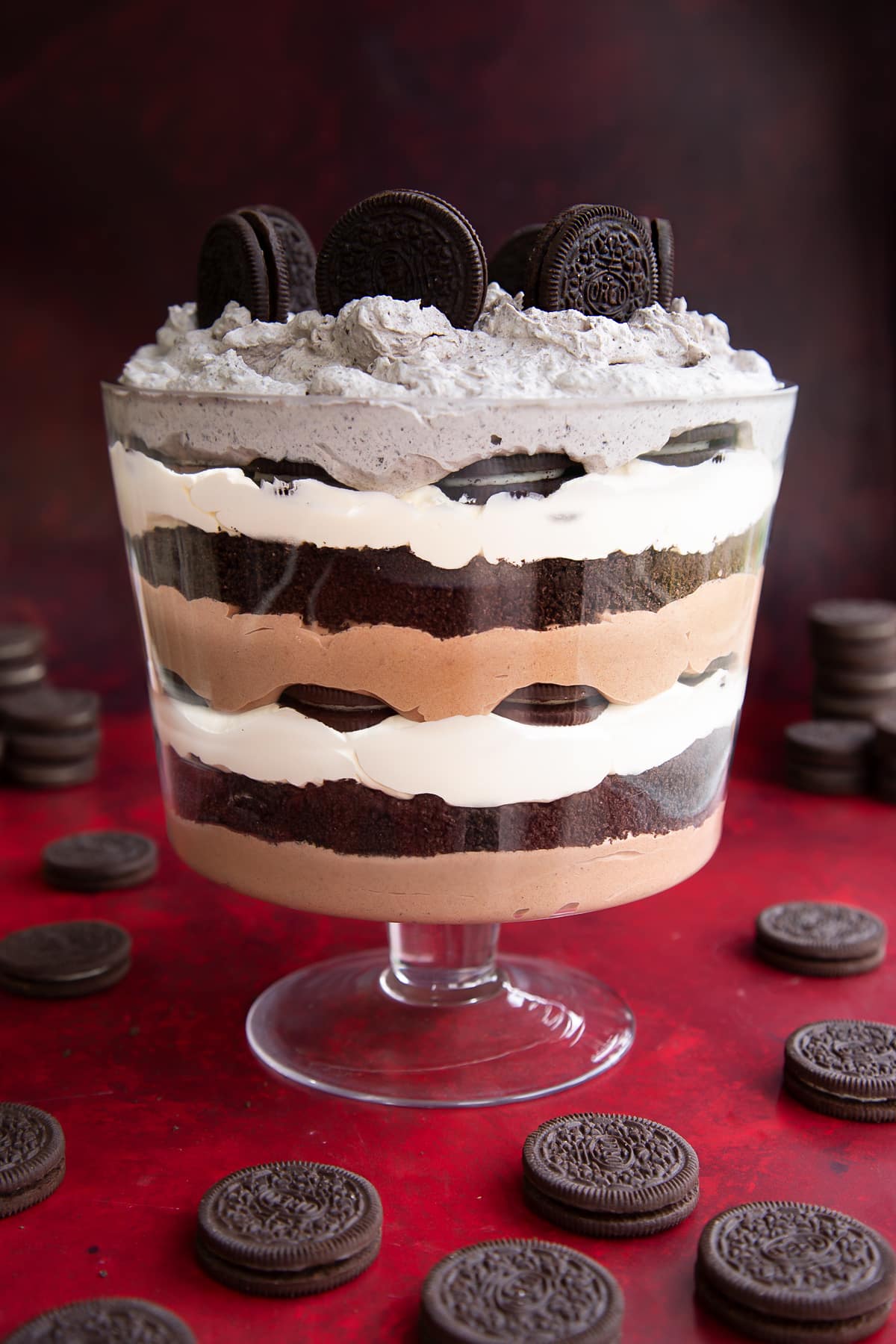 Oreo trifle with layers of chocolate pudding, whipped cream and Oreos. Oreos stand on the top.