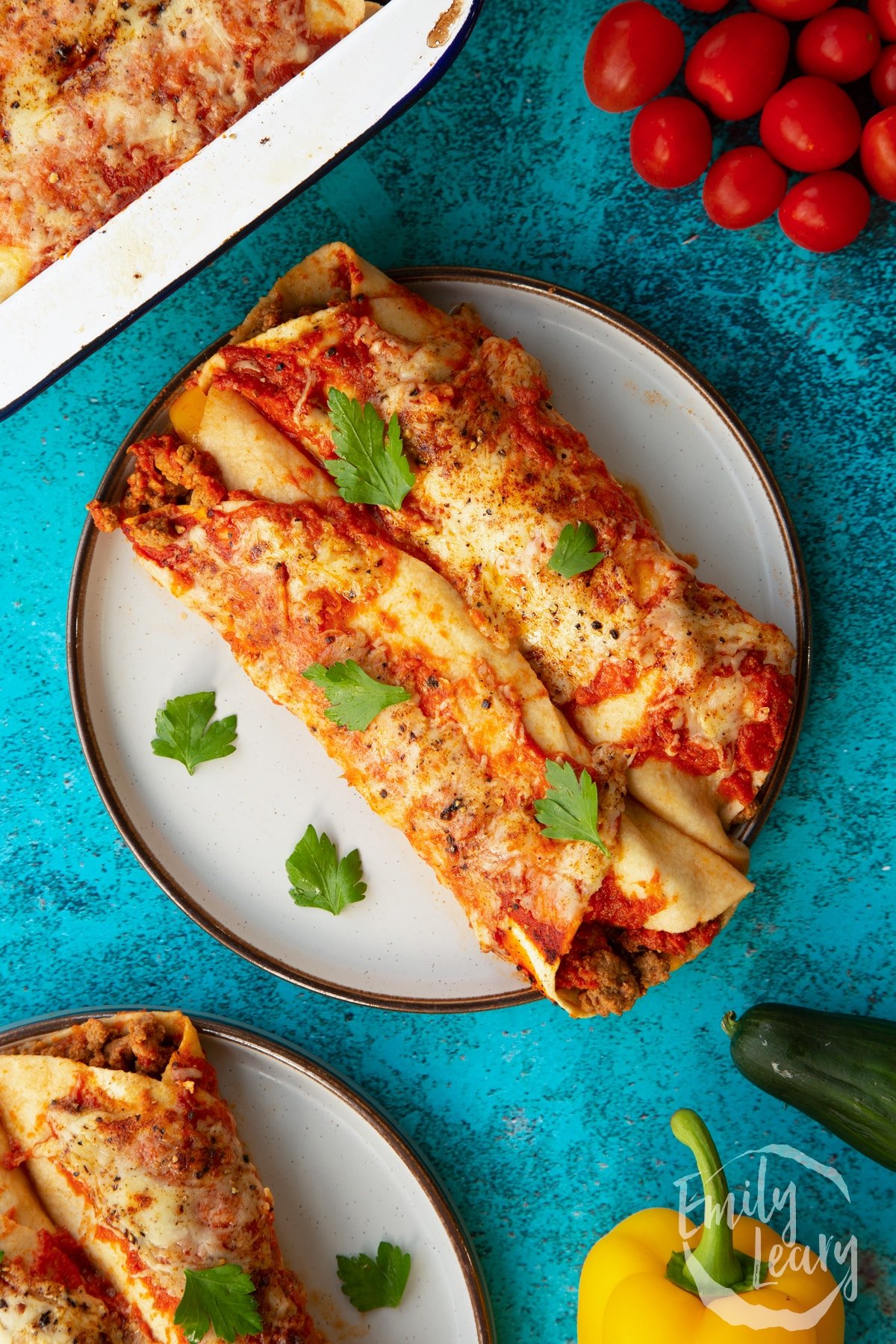 Quorn mince enchiladas served on a grey plate. Garnished with parsley. Shown from above.