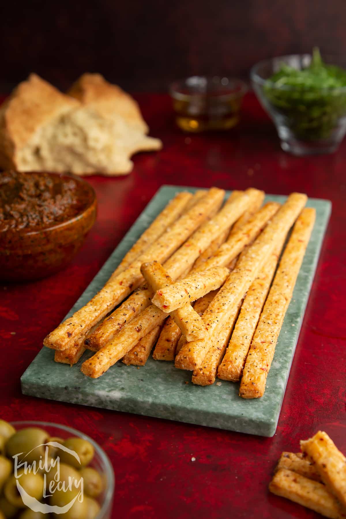 Side on shot of the finished spicy cheese straws on a decoarive board.