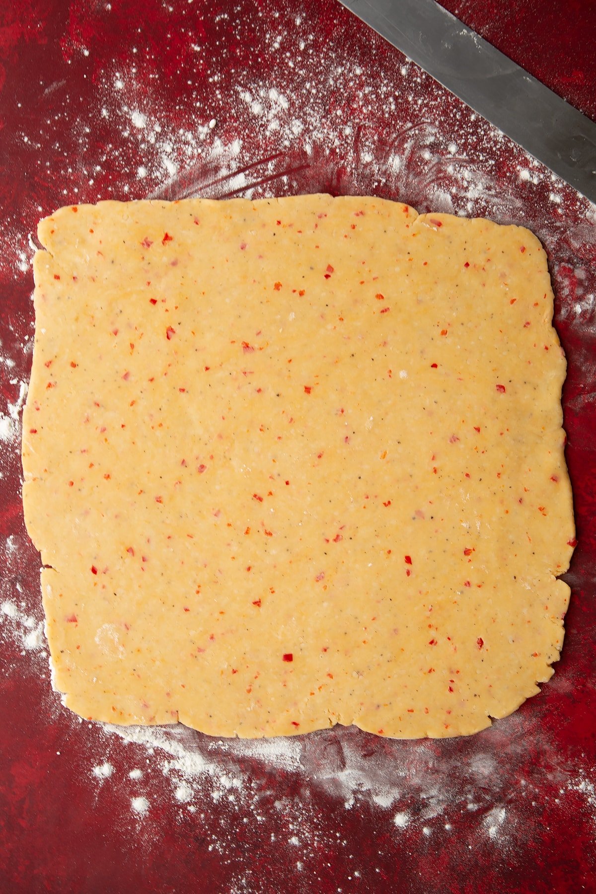 Overhead shot of the spicy cheese straws dough having been rolled out on a lightly floured surface.