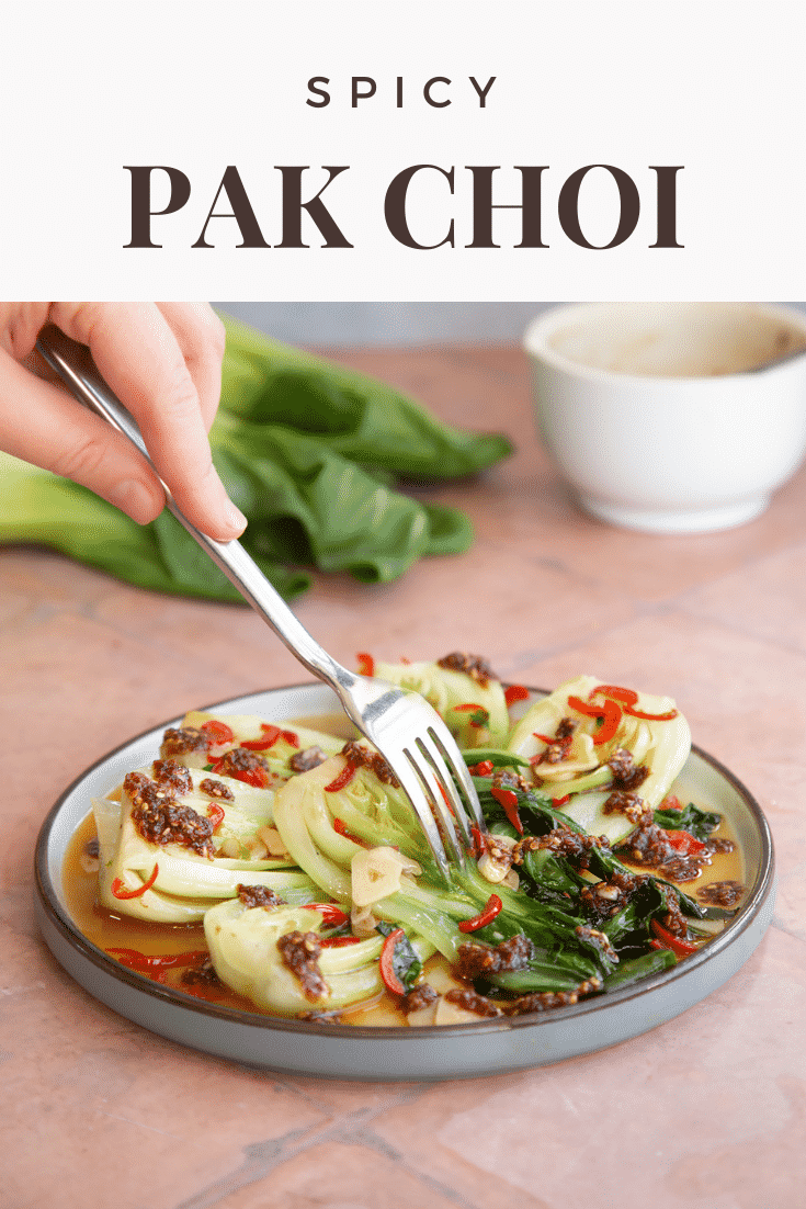 Spicy pak choi served on a plate with a fork coming in from the top with text at the top describing the image for Pinterest.