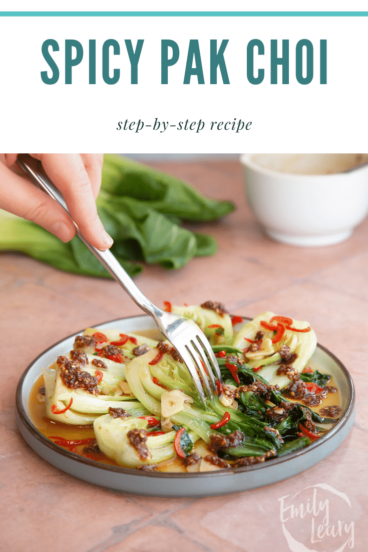 Spicy pak choi served on a plate with a fork coming in from the top with text at the top describing the image for Pinterest.