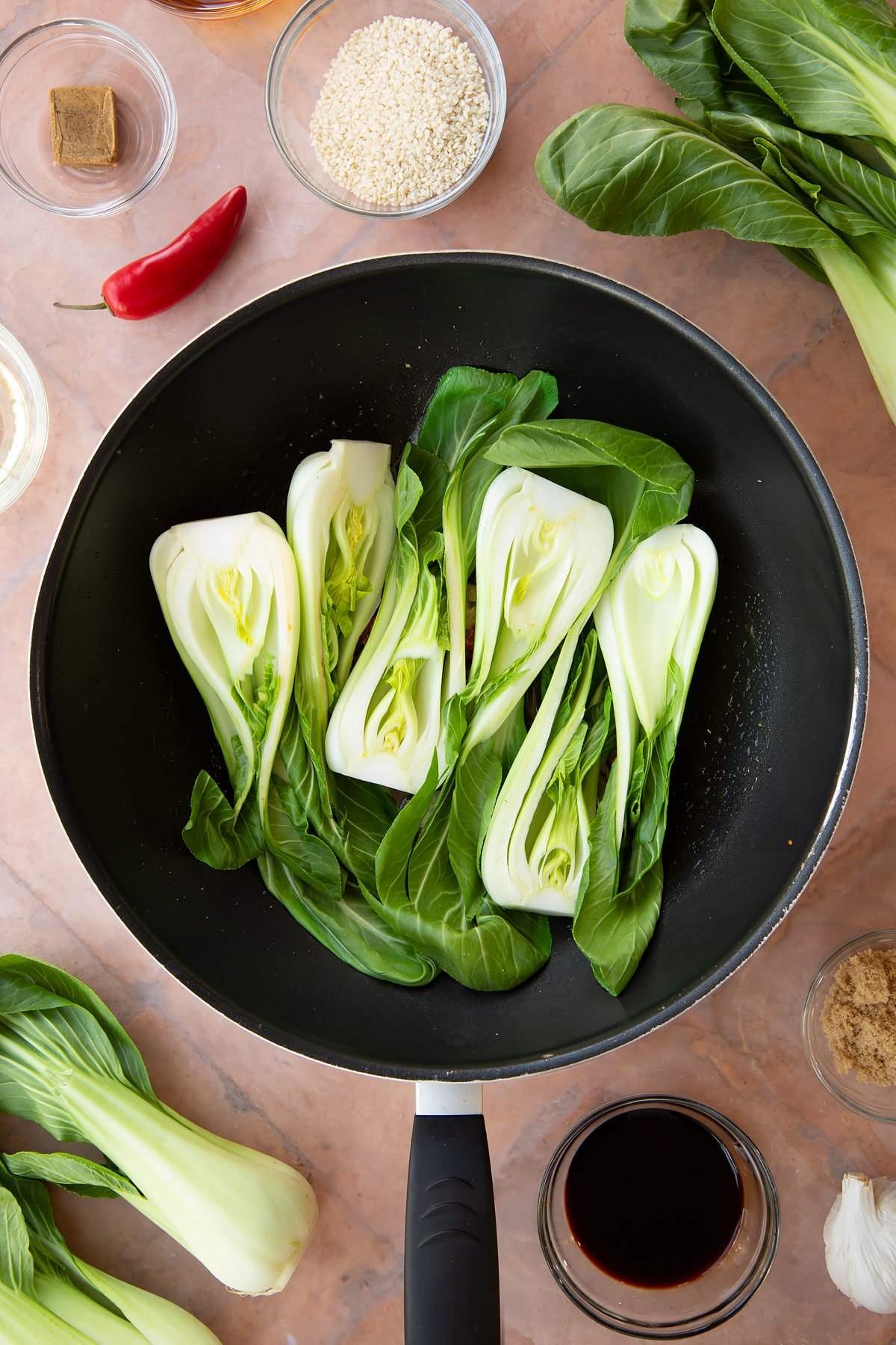 Adding the pak choi to the pan of ingredients.