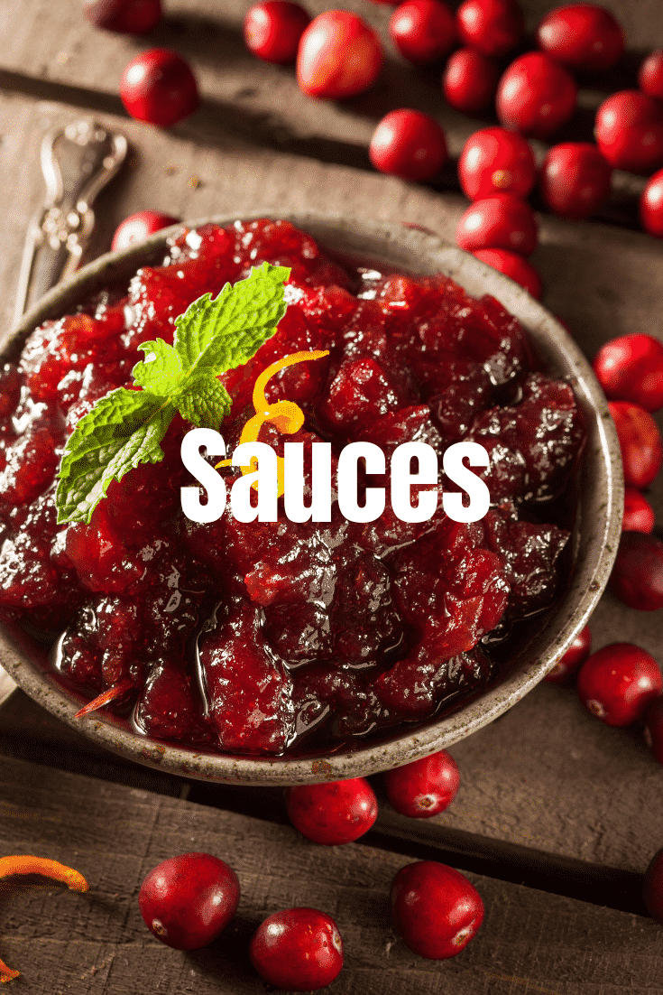 Overhead shot of a small bowl of cranberry sauce surrounded by cranberry's with text ontop that says sauces