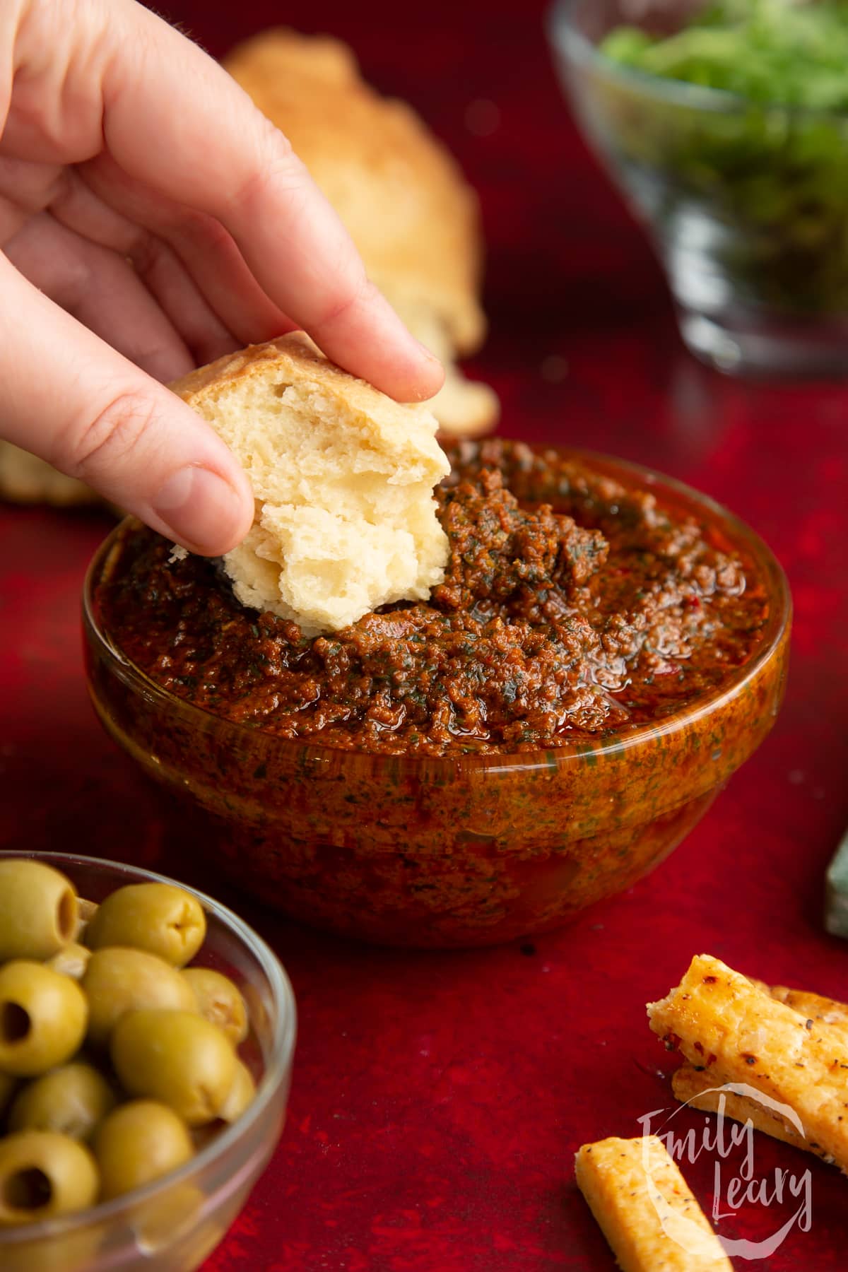 Side on shot of the dish of chilli pesto with a small slice of bread.