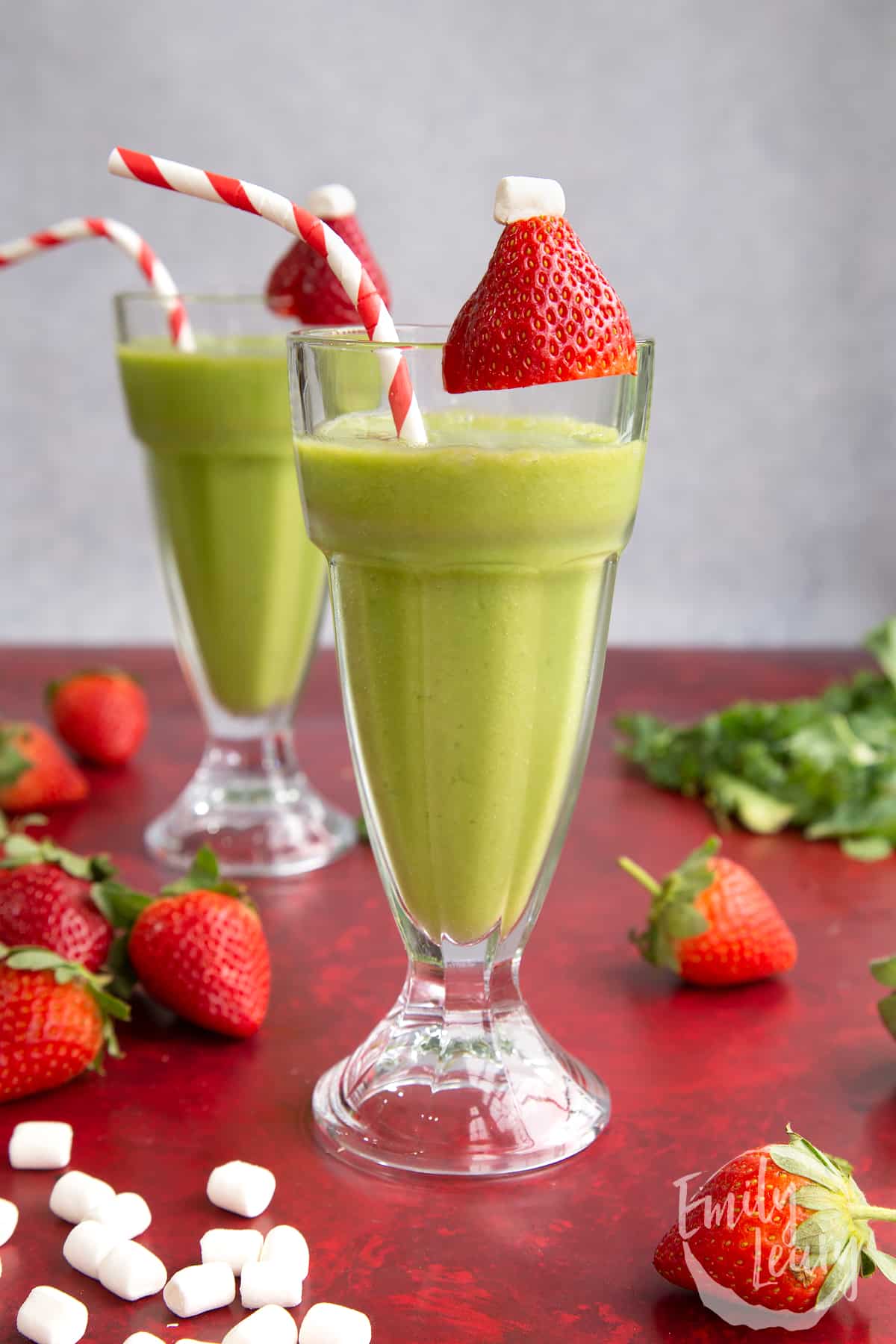 The Grinch drink with a strawberry and marshmallow on top, looking like Santa's hat