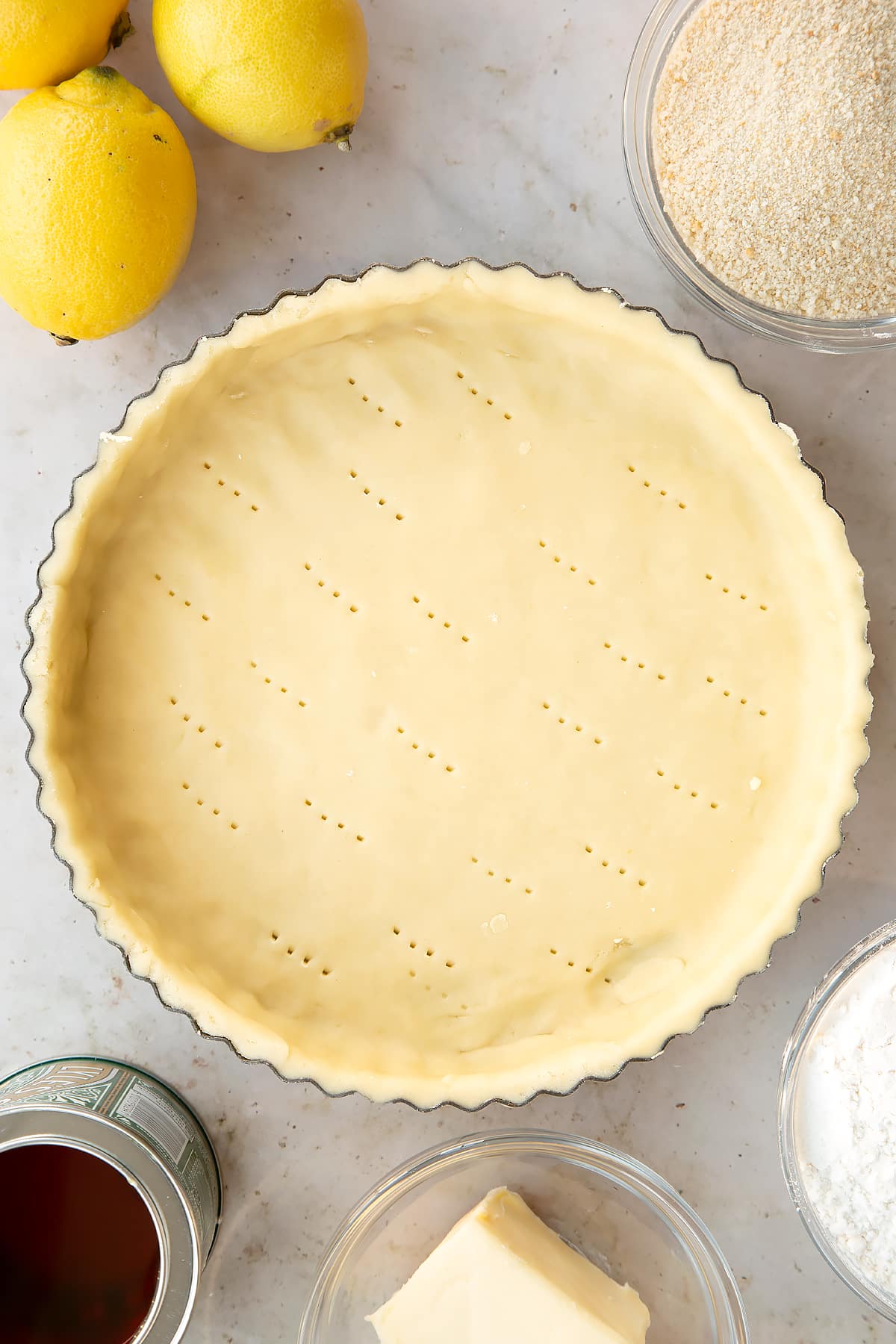 Overhead shot of the pastry tin after being pricked multiple times with a fork.