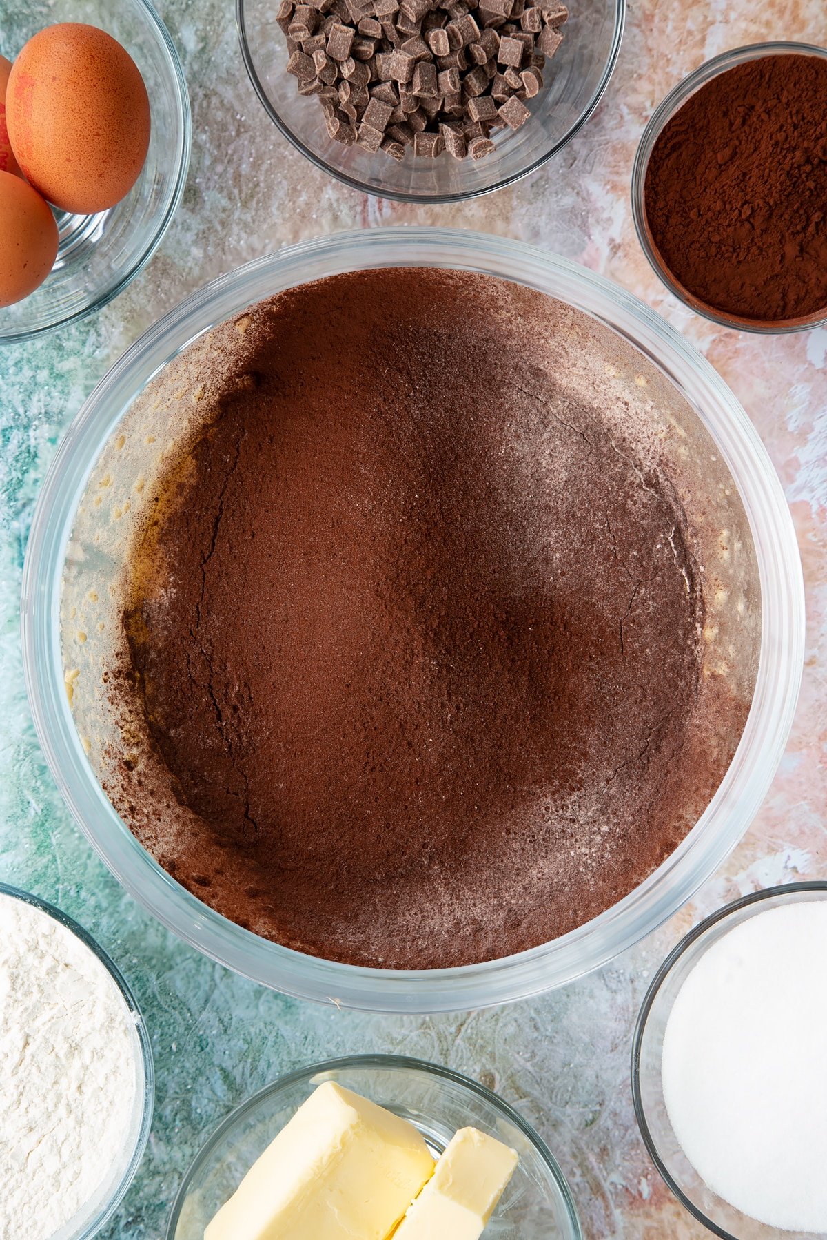 Overhead shot of adding in the flour and cocoa powder to the bowl of ingredients