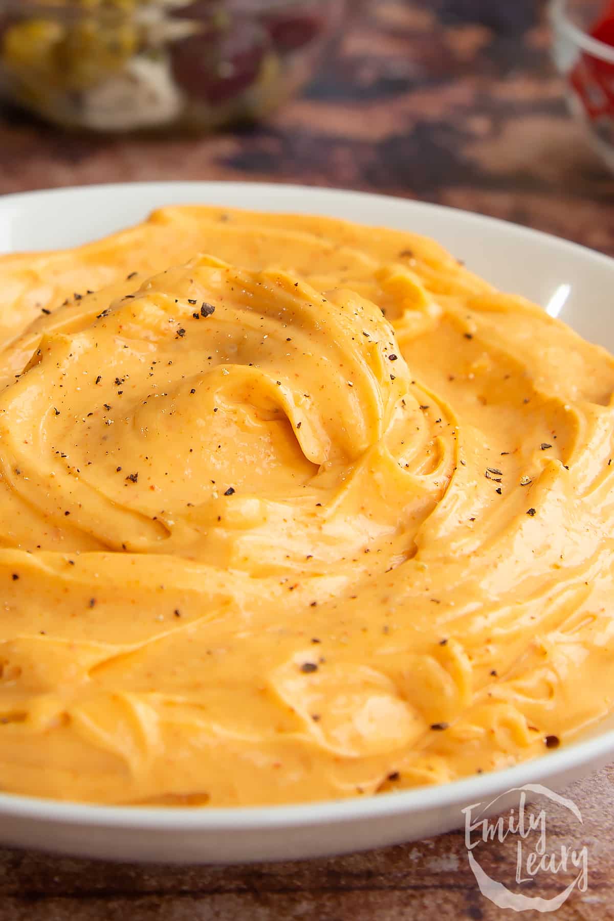 Close up of paprika mayo in a shallow white bowl.