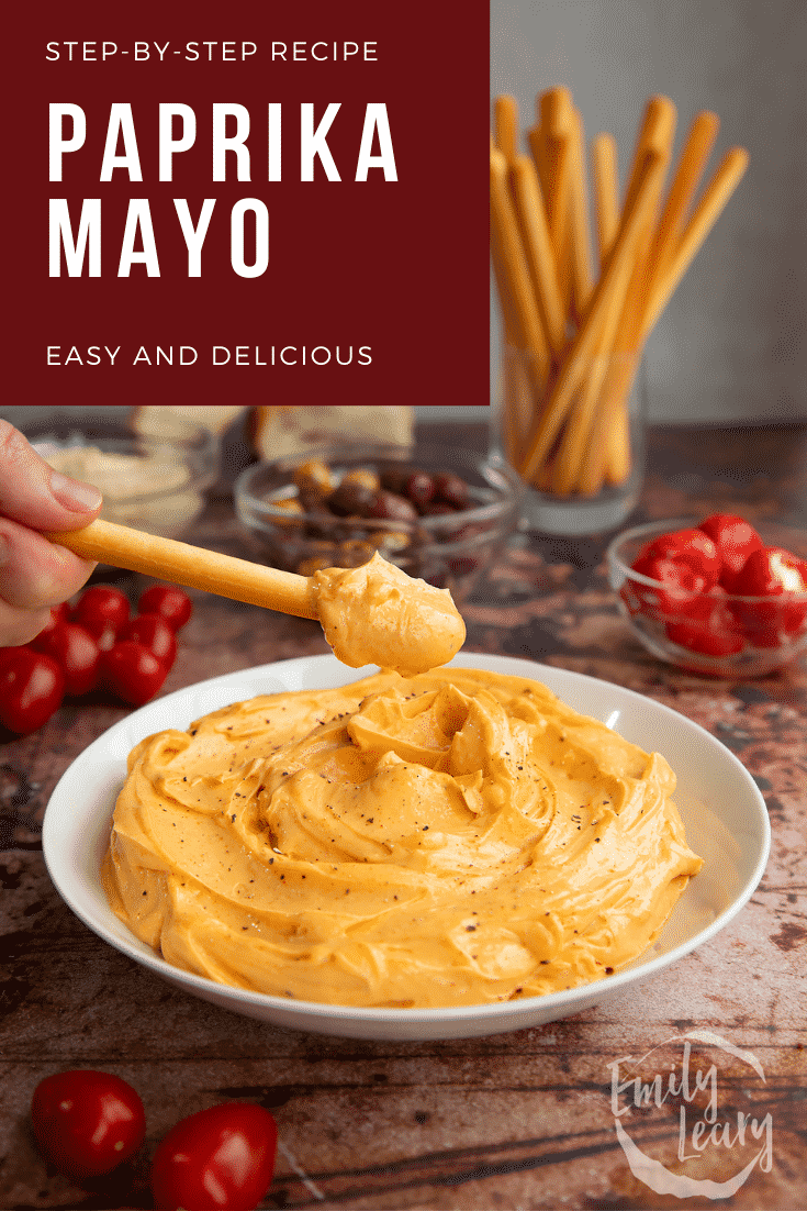 Paprika mayo in a shallow white bowl.  A breadstick is being dipped in. Caption reads: Step-by-step recipe. Paprika mayo. Easy and delicious.