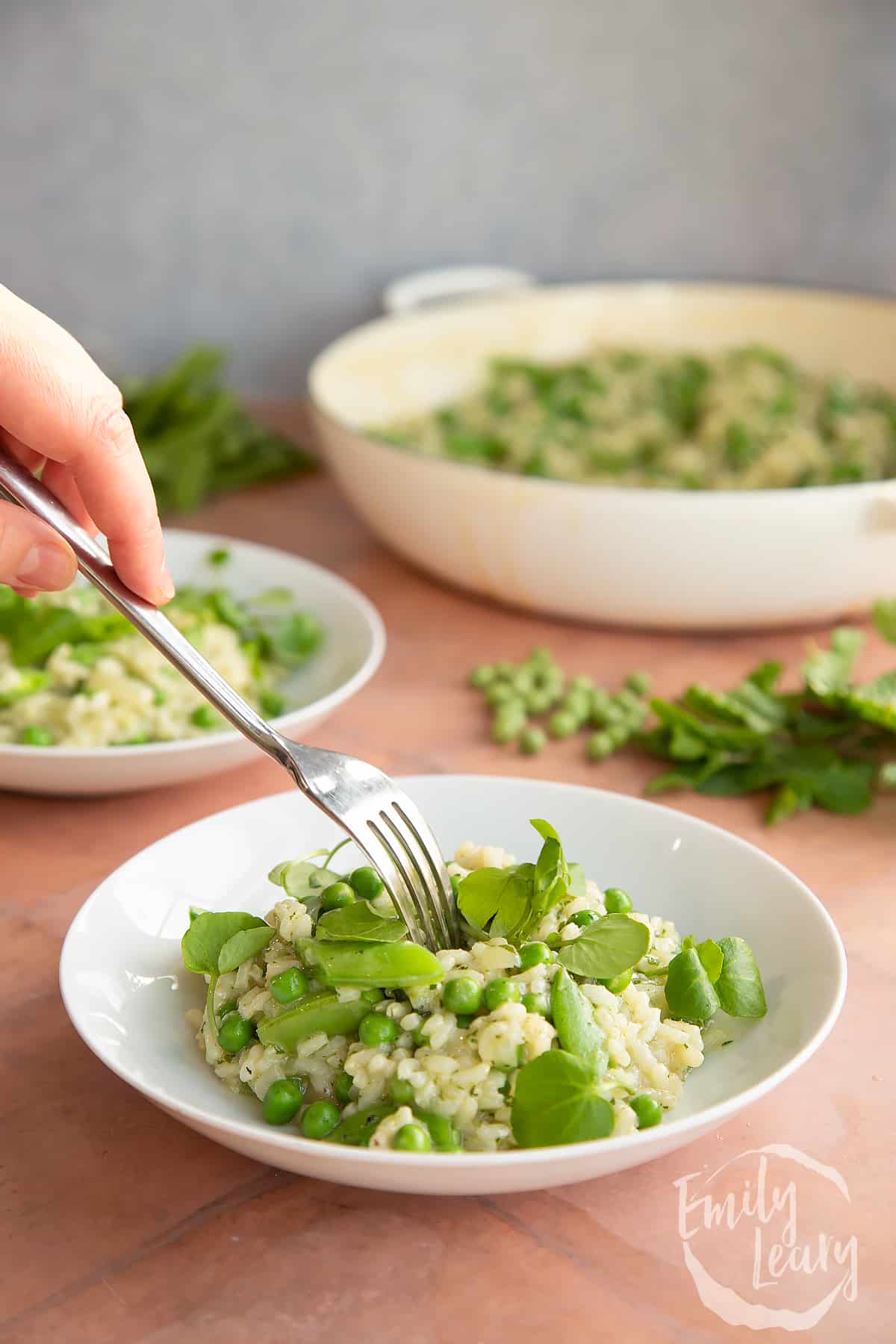 Fork going into a bowl of the pea and mint risotto. 